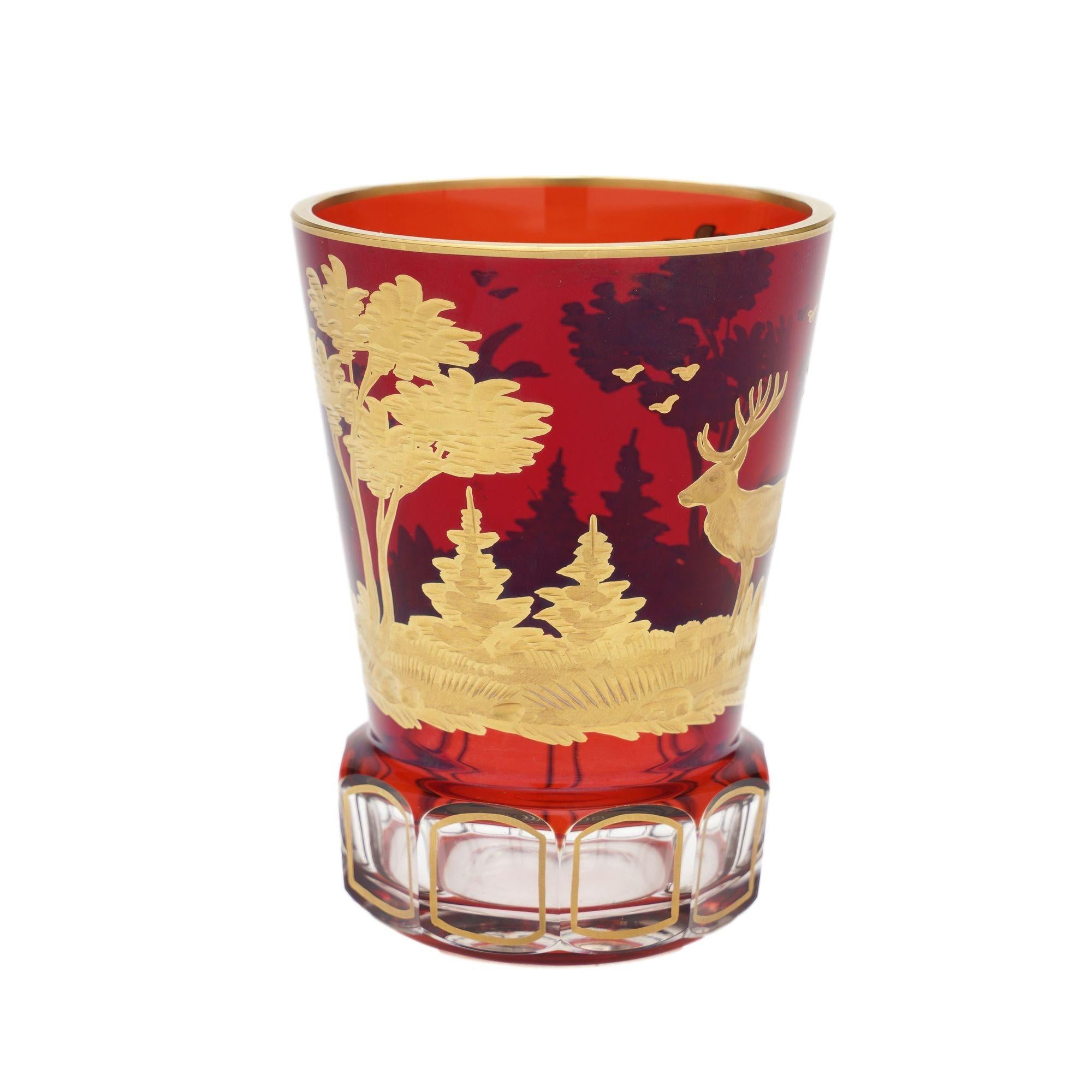 Exceptional quality spa glass tumbler in clear blown and cased ruby glass. The tumbler has been cut and etched with a forest scene in gilt. The scene depicted is of a stag standing in a meadow, surrounded by a variety of trees, with two ducks in