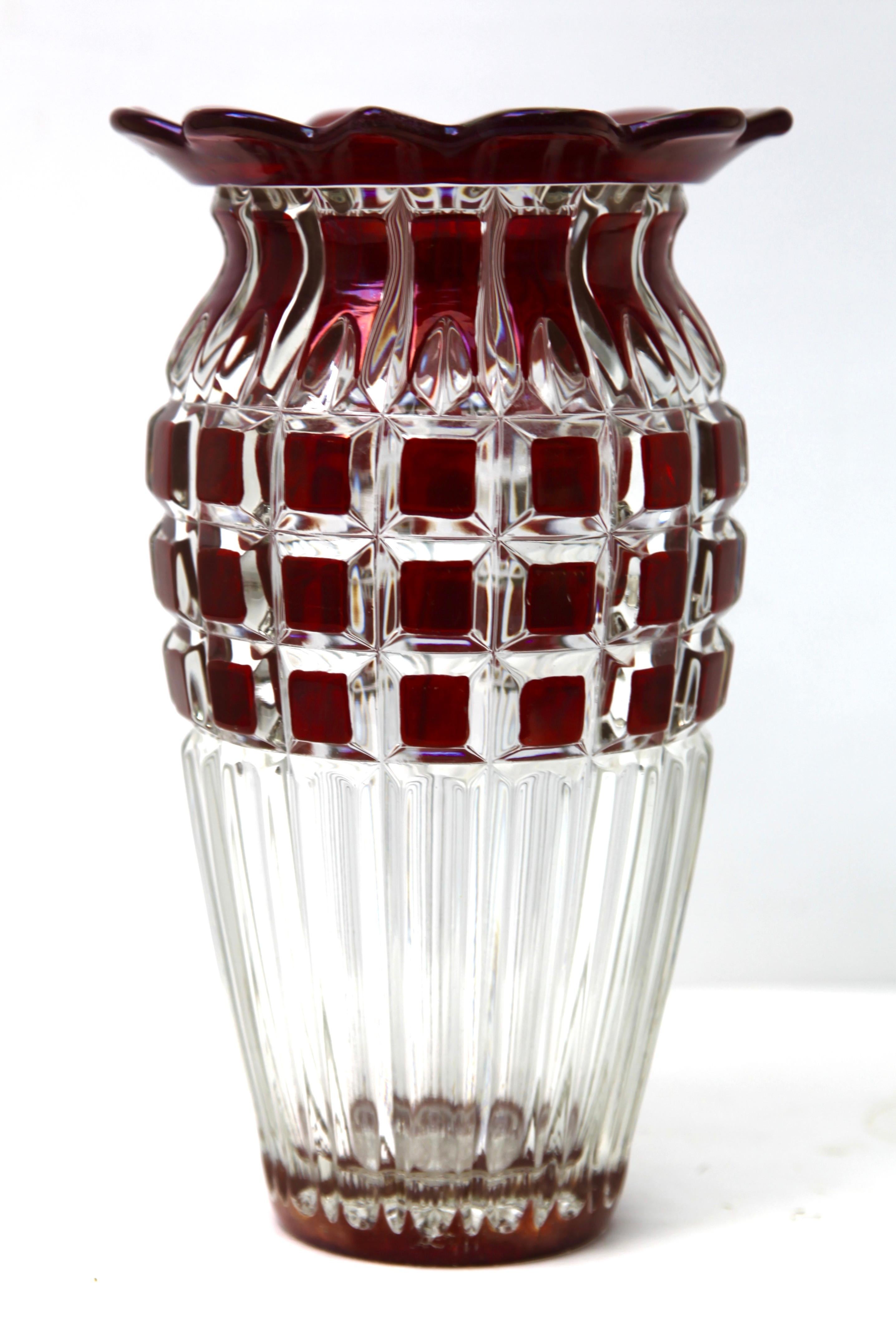 Vibrant, Cranberry collard cased-crystal glass vase in the Bohemian style with cut-to-clear geometric decoration. 
The body contains a good amount of water to keep the arrangement stable and blooming.

Very colorful and a nice bright addition for