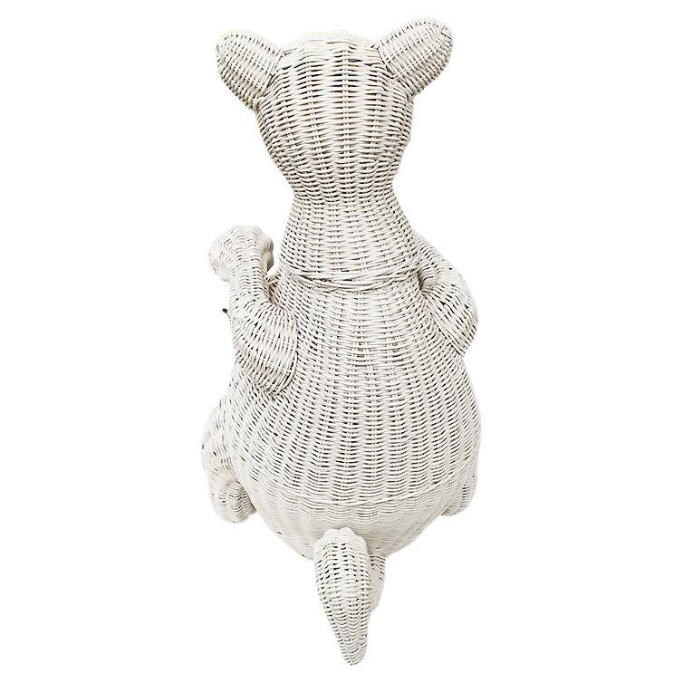 A bohemian white wicker decorative basket or plater in the shape of a kangaroo. Created from woven wicker, and painted in a crisp white, this fun basket is woven to resemble a kangaroo. His belly is open and will be great to hold a plant or other