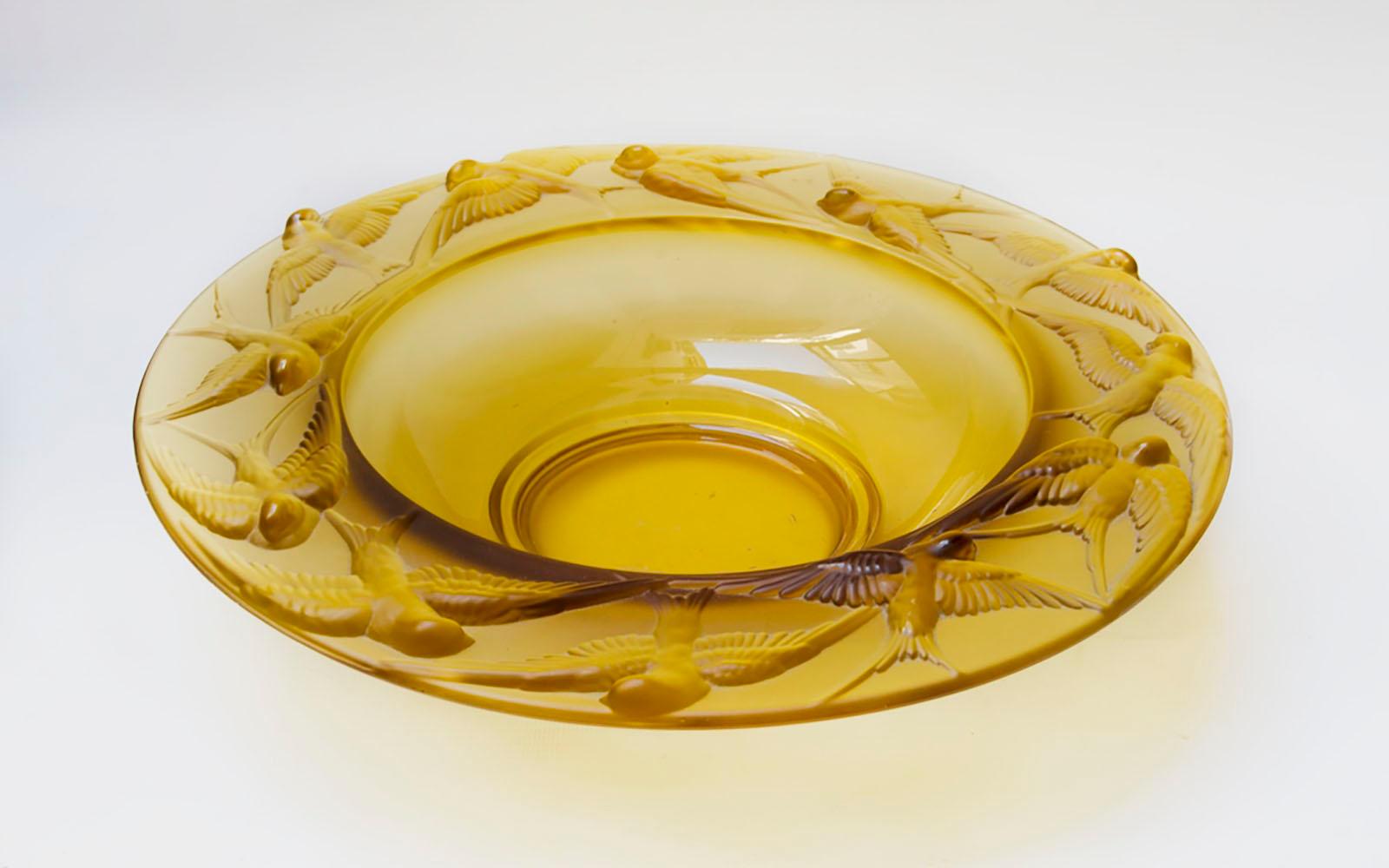 Bohemian yellow glass centerpiece from the 19th century

Striking centerpiece of the Bohemia deep plate made of European yellow glass, which has beautiful swallows carved on its edge, perfect for those maximalist environments.
Measures:
Height: 7.5
