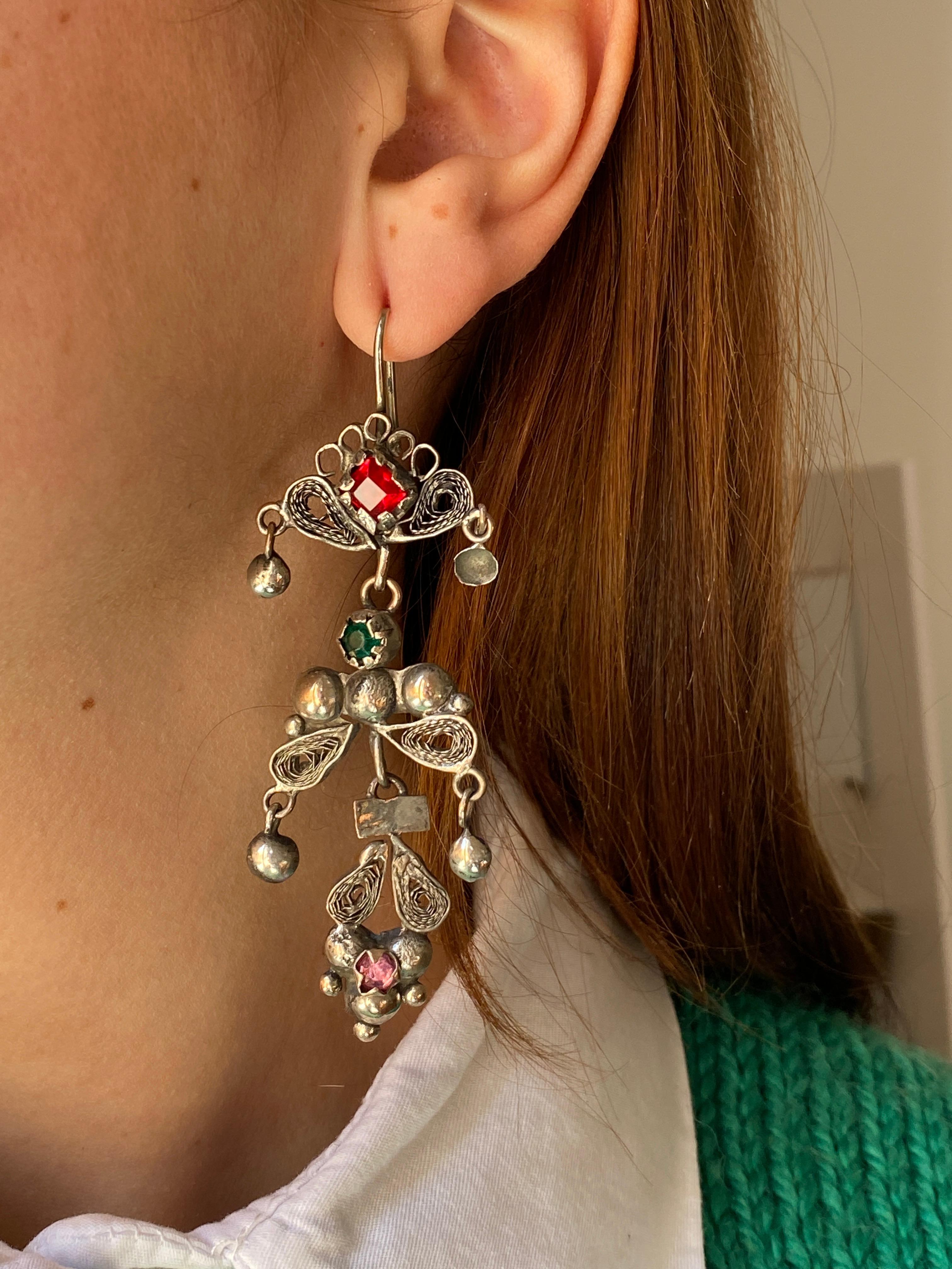 Introducing these exquisite filigree hens crafted earrings, comprised of three jointed parts. The hook effortlessly fits onto the lobe, suspending a floral and feminine design with a captivating bohemian and vintage allure. Adorned with glass stones