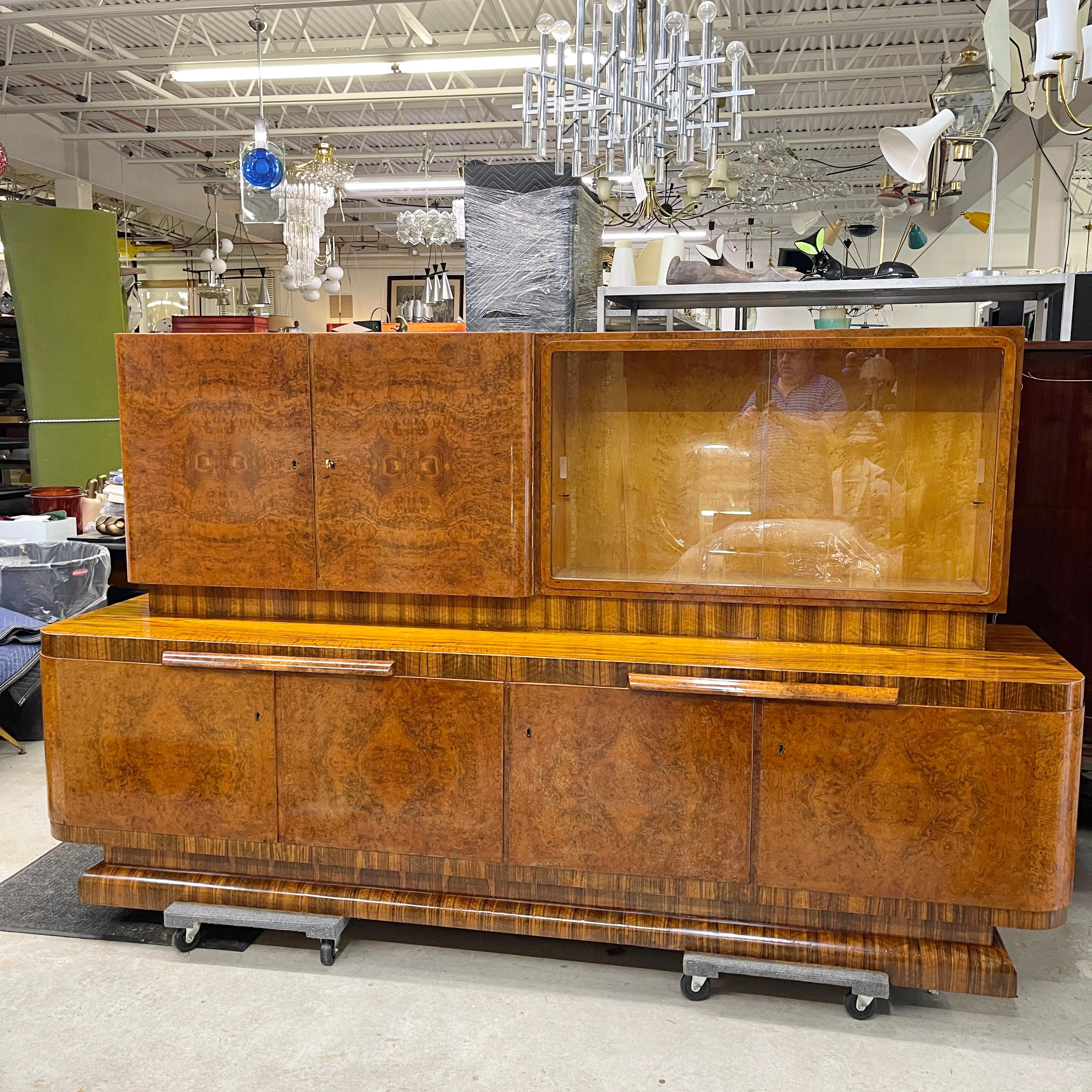 Grand scale European Art Deco sideboard buffet china cabinet, circa 1930, with curved ends, unmarked but probably German or Eastern European, in exquisite bookmatched burlwood veneers and tons of storage space for all your china, silver, glassware