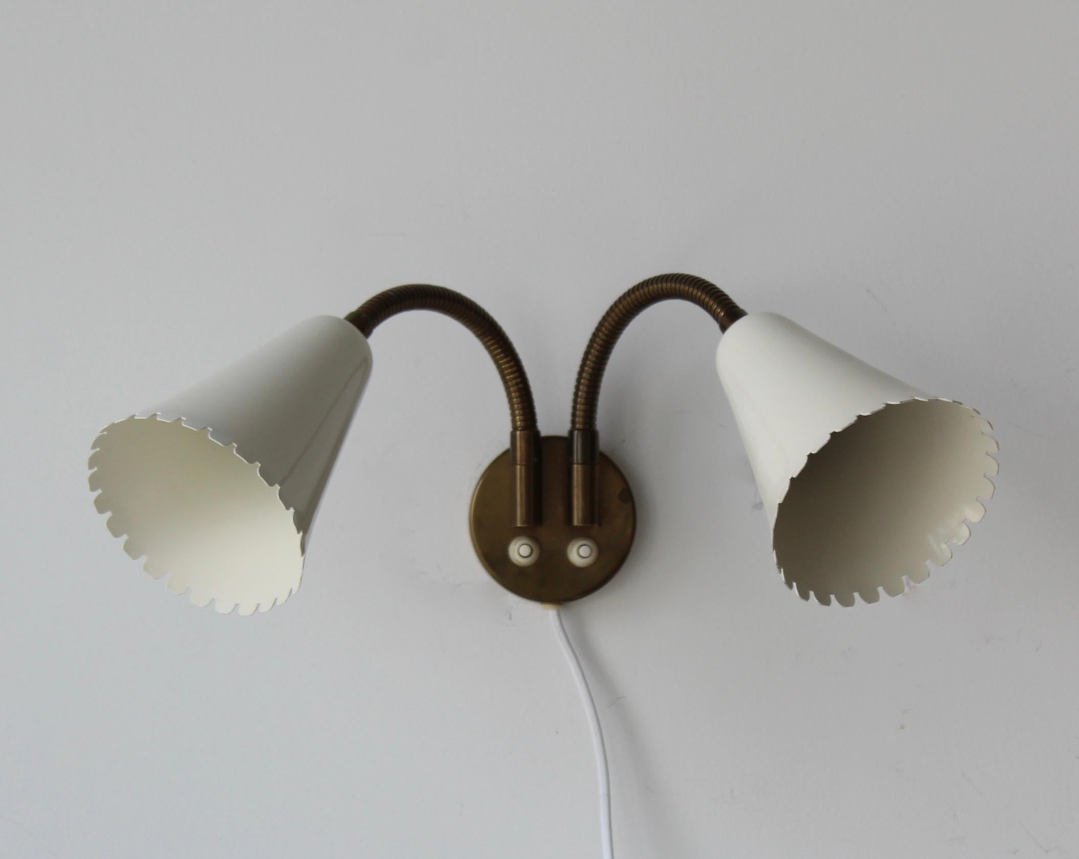 An adjustable organic wall light / sconce. Designed and produced by Böhlmarks, Sweden, 1950s. In brass and black-lacquered metal. Markings indicate patented design. 

Each arm takes one lightbulb on standard medium socket. No stated max wattage on