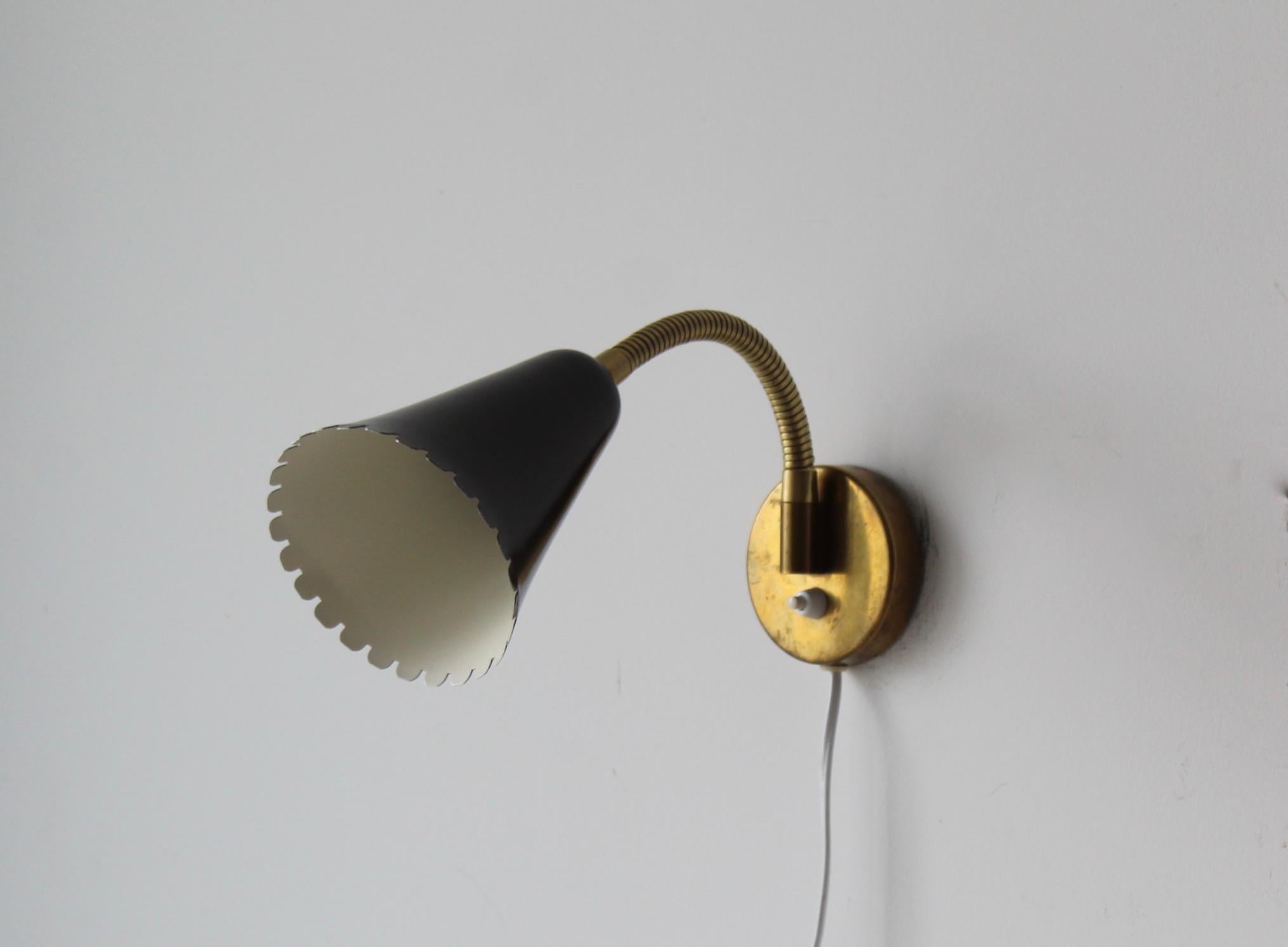 A pair of adjustable organic wall light / sconce. Designed and produced by Böhlmarks, Sweden, 1950s. In brass and black-lacquered metal. Markings indicate patented design. 

The arm takes one lightbulb on standard medium socket. No stated max