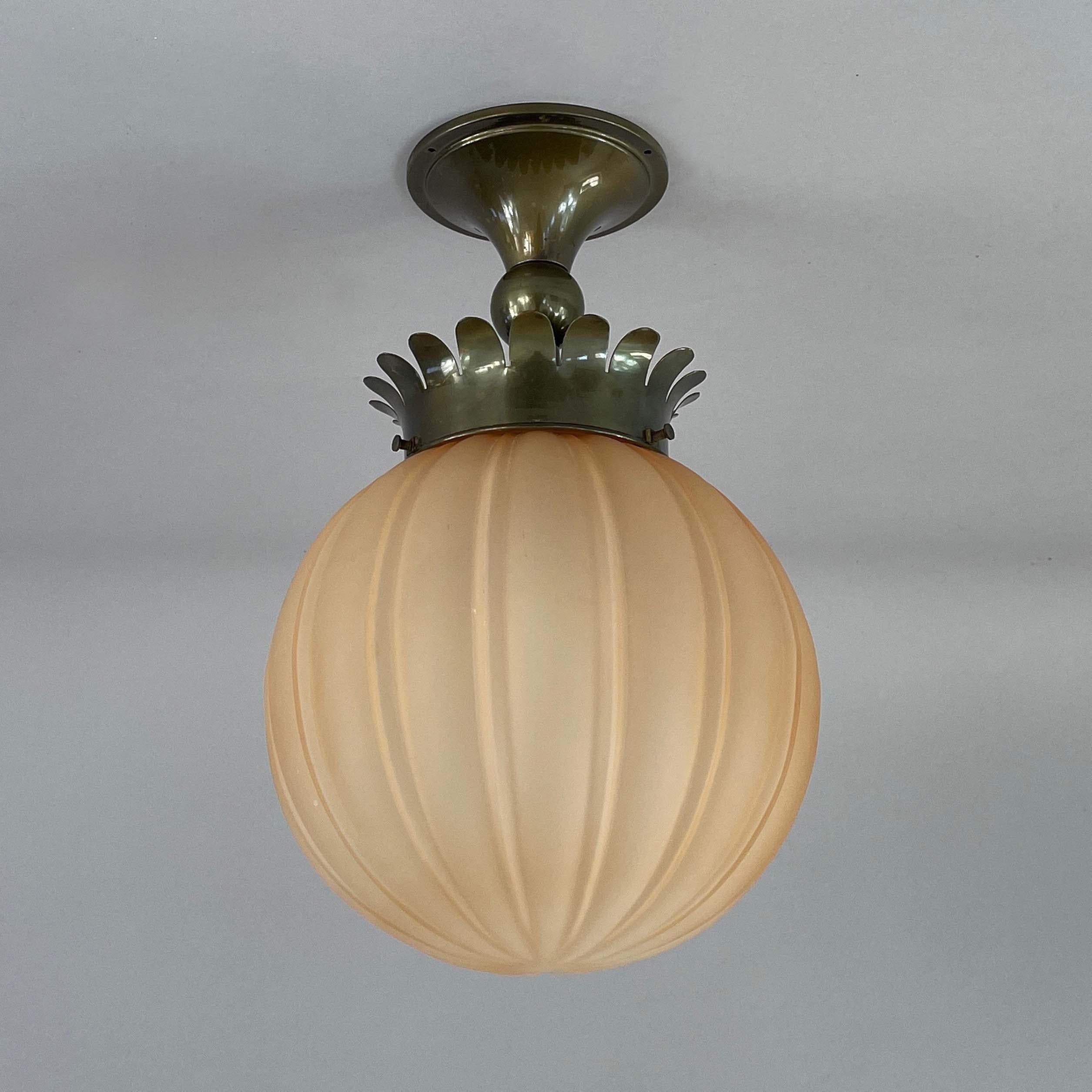 This Art Deco flush mount was designed and manufactured in Sweden in the 1930s. It features a distinct Art Deco design, characterized by its elegant combination of materials and shapes.

The globe-shaped glass shade is ribbed, providing a soft