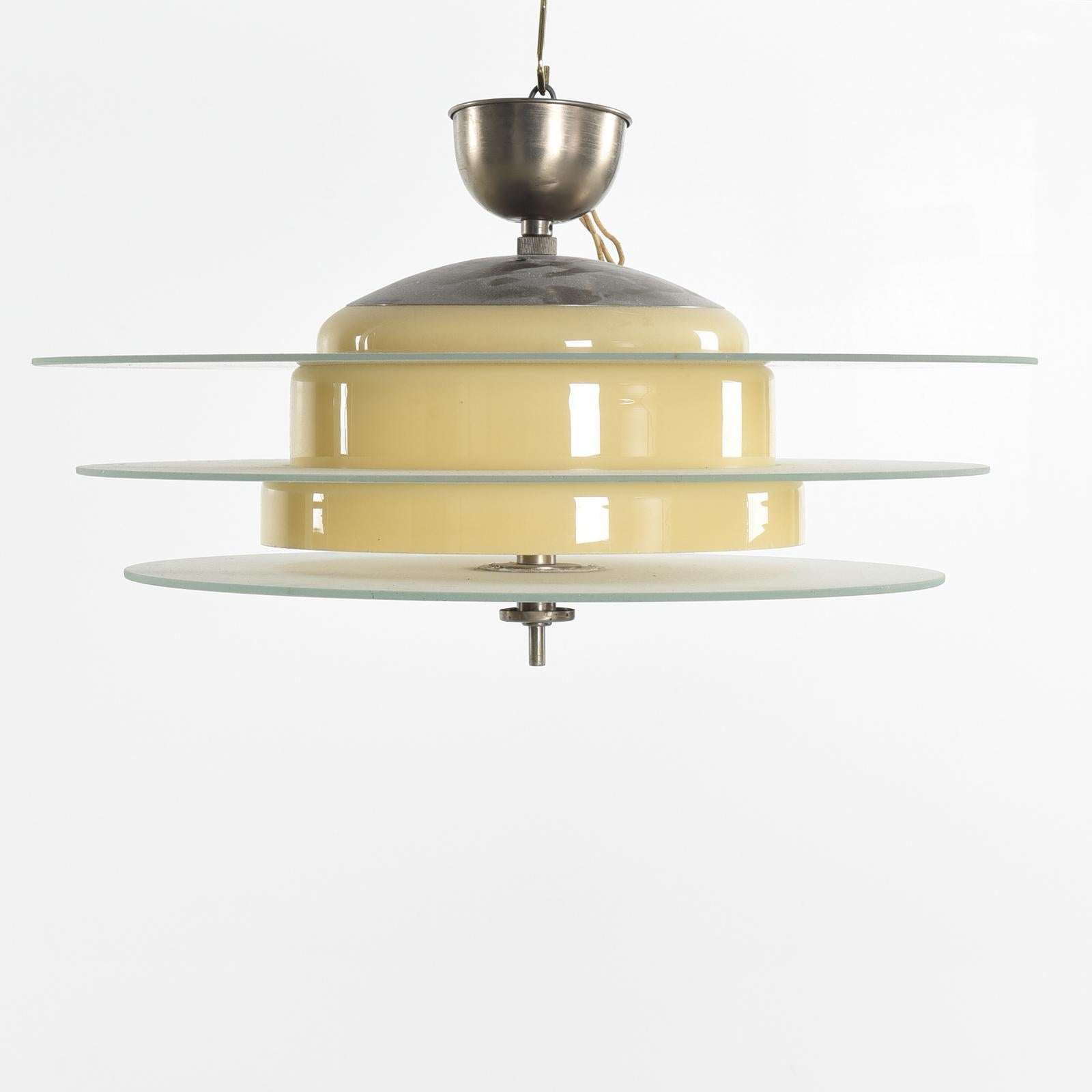 Art Deco chandelier with a nickel-plated brass frame, glass shade. Fitted with 3 E26/E27 porcelain sockets up to 100watts each. Designed by Harald Notini and manufactured in Sweden by Böhlmarks Lampfabrik in the 1930s. 
The length will be customized