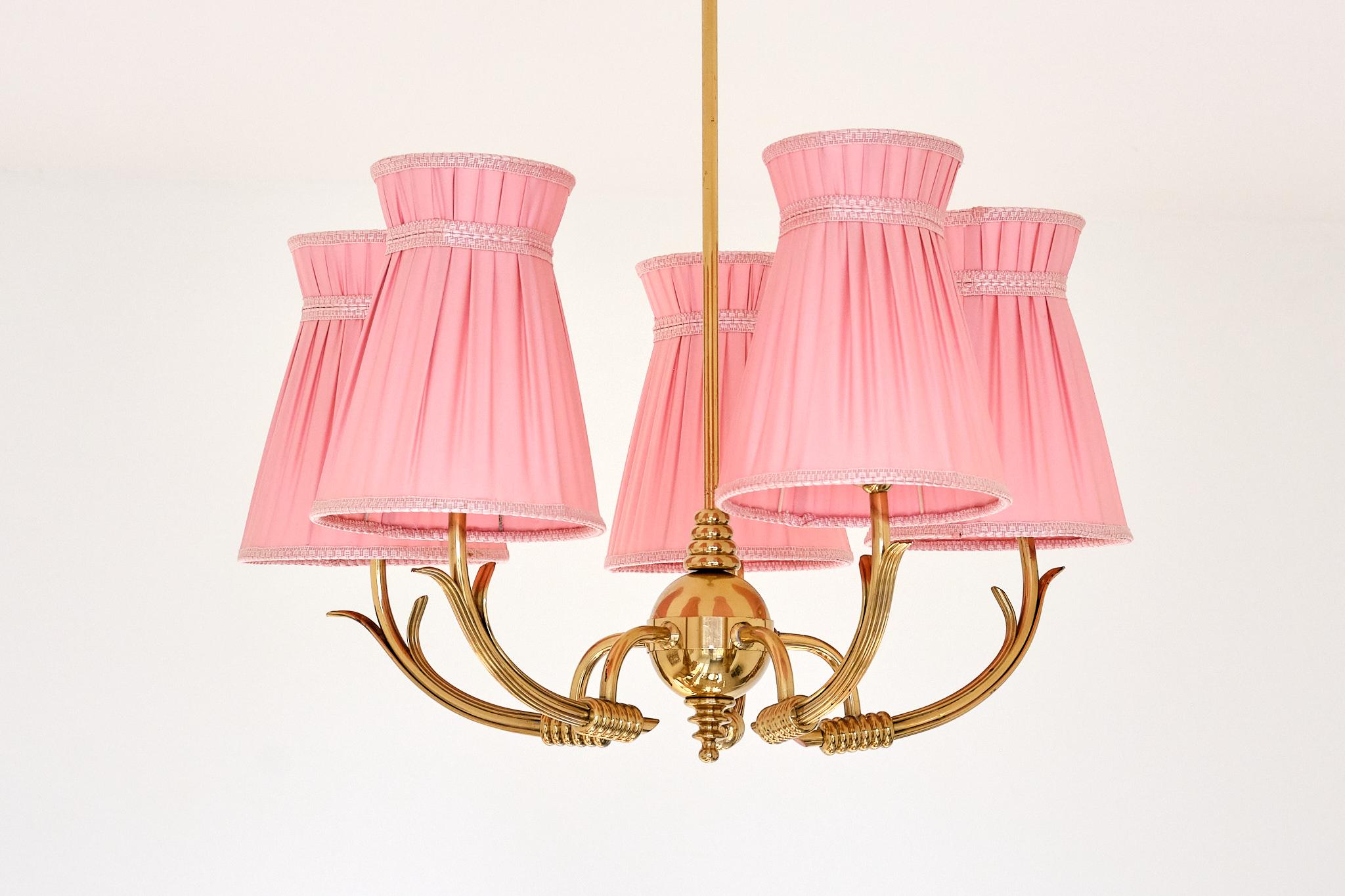 Ce lustre à cinq branches, exceptionnellement rare, a été produit en Suède dans les années 1950 et est attribué à Arvid Böhlmarks Lampfabrik.

Le design présente un corps à cinq bras en laiton massif. Les bras incurvés ont une structure en laiton