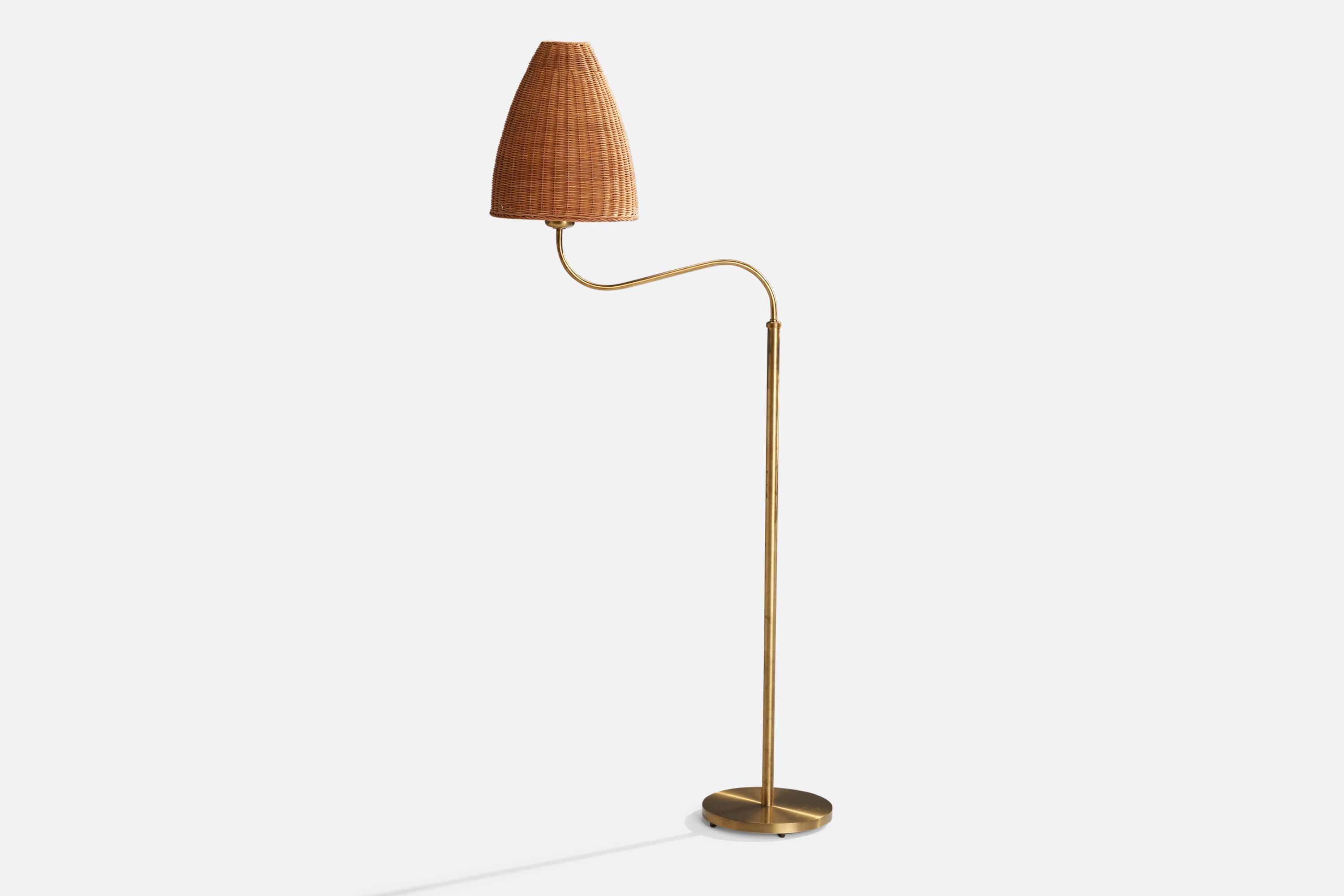 An adjustable brass and rattan floor lamp produced by Böhlmarks, Sweden, c. 1940s.

Dimensions variable, measured as illustrated in first image.

Sold with lampshade.