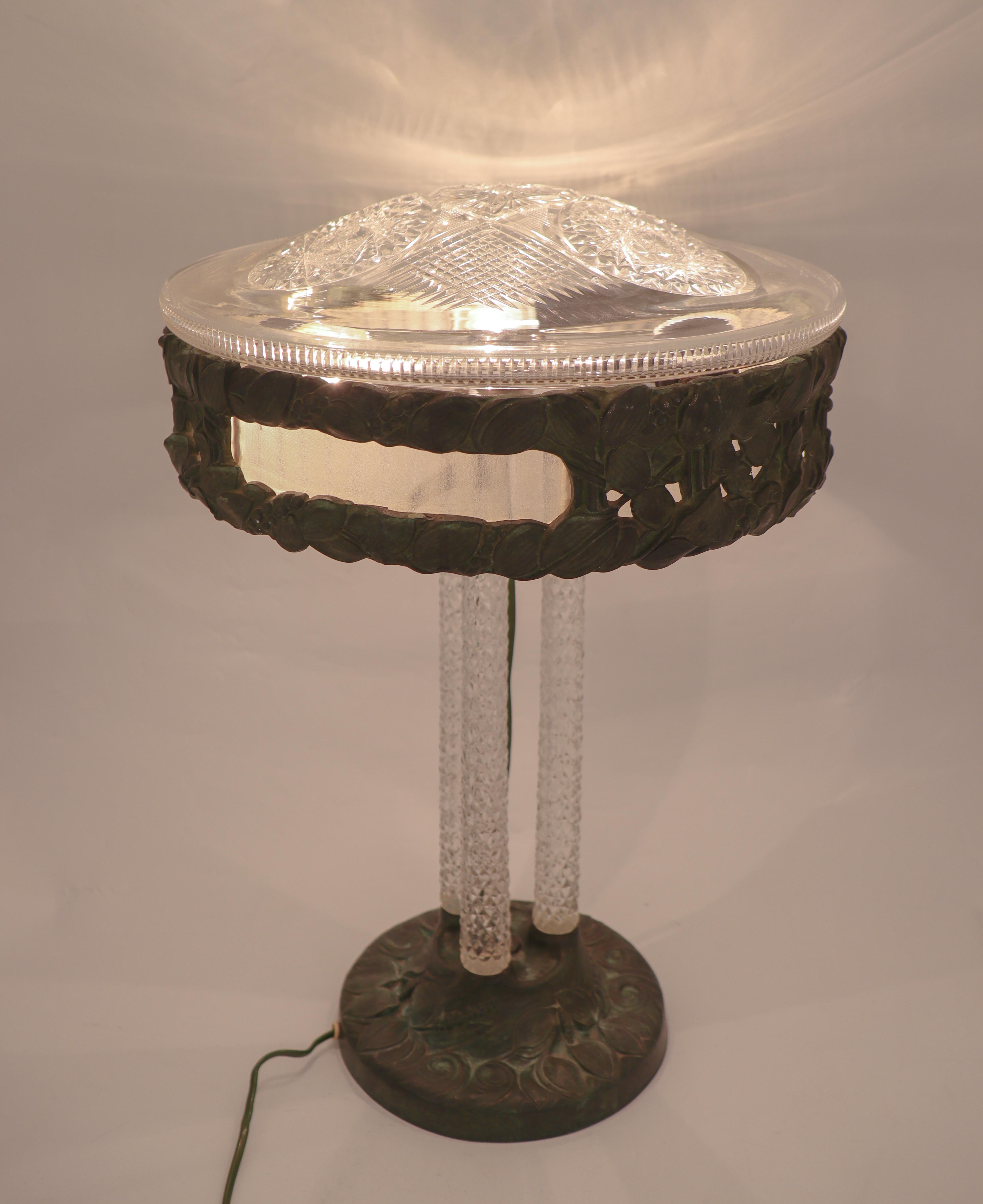 A stunning and very rare table lamp from Arvid Böhlmarks Lamp factory in Stockholm. This lamp was designed in 1909 and has a base and top in bronze, stunning crystal columns and a crystal lamp shade. The lamp is pictured and described in Böhlmarks