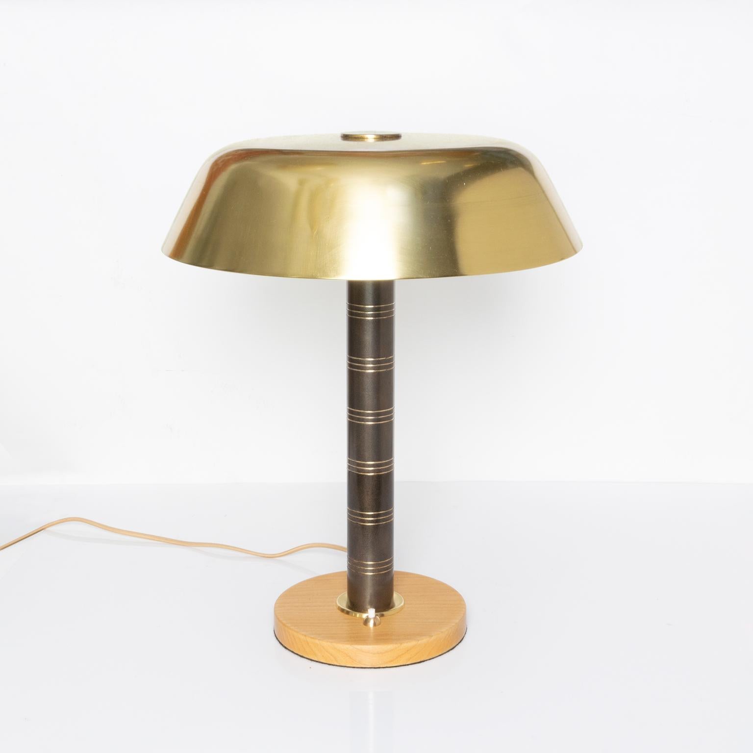 Scandinavian Modern polished and patinated brass lamp with a solid oak base. Lamp has been fully restored and re-wired with 2 standard base sockets for use in the USA. Made by Bohlmarks, Sweden 1940-1950.

Measures: Shade diameter: 13.5” Height: 17“.