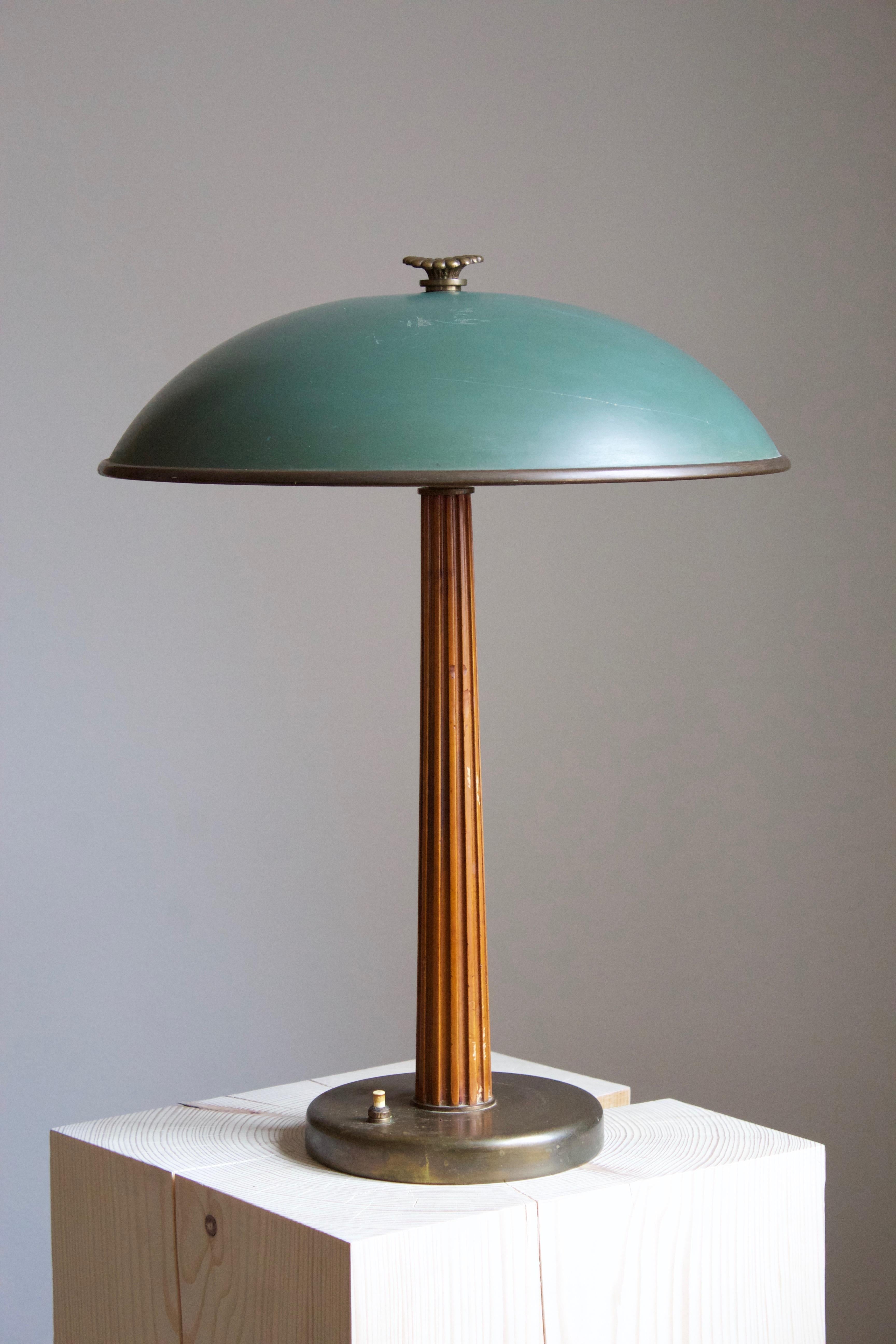 A modernist table lamp or desk light. Produced by the iconic Swedish lamp maker Böhlmarks. Produced in 1935. Features engraving in Swedish, with dating.

Features a finely sculpted lacquered wood handle on a brass rod and base, original lacquered