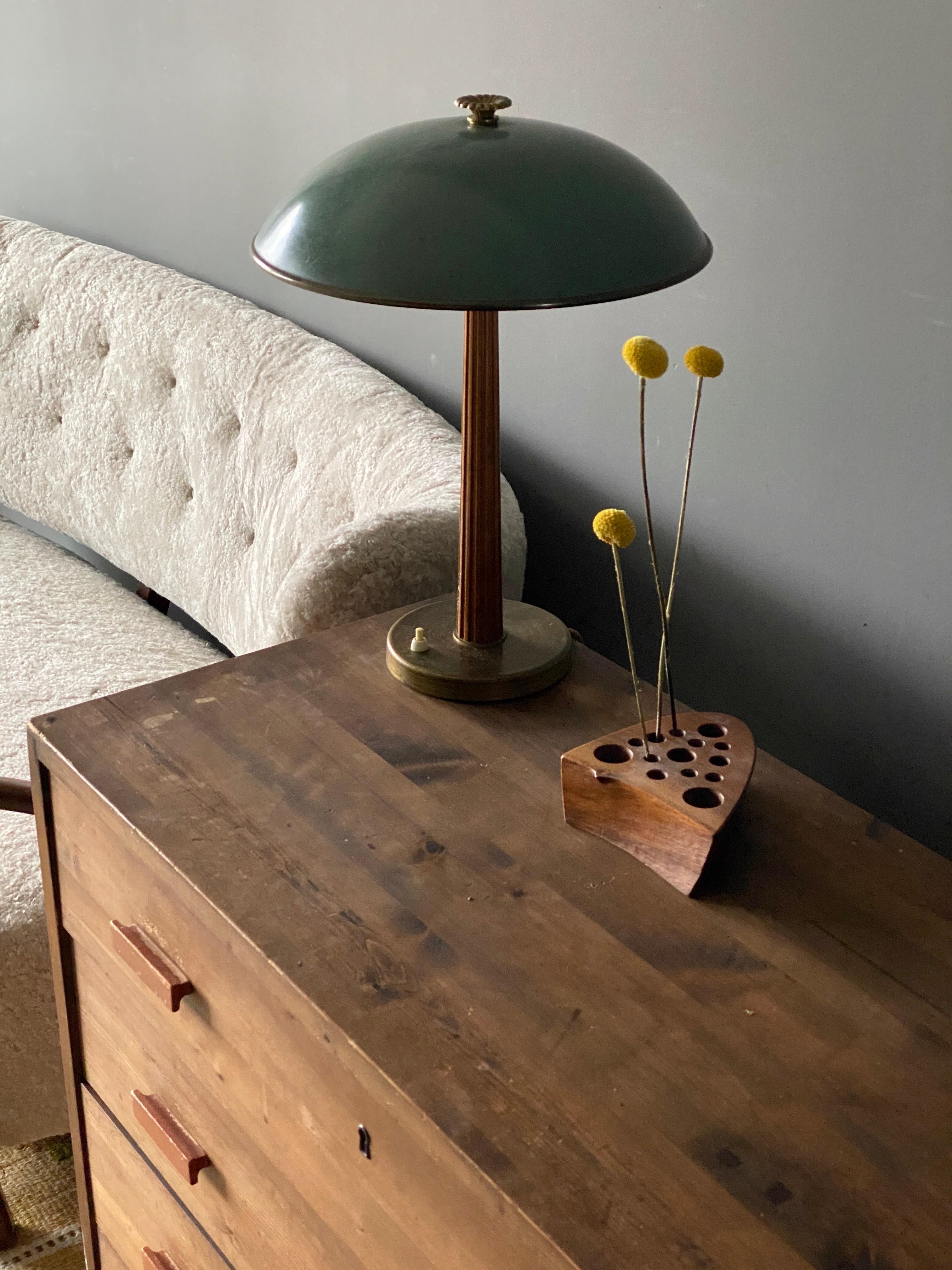 A modernist table lamp or desk light. Produced by the iconic Swedish lamp maker Böhlmarks, circa 1940. Of superb quality. 

Features a finely sculpted lacquered wood handle on a brass rod and base, original lacquered metal screen.

Other