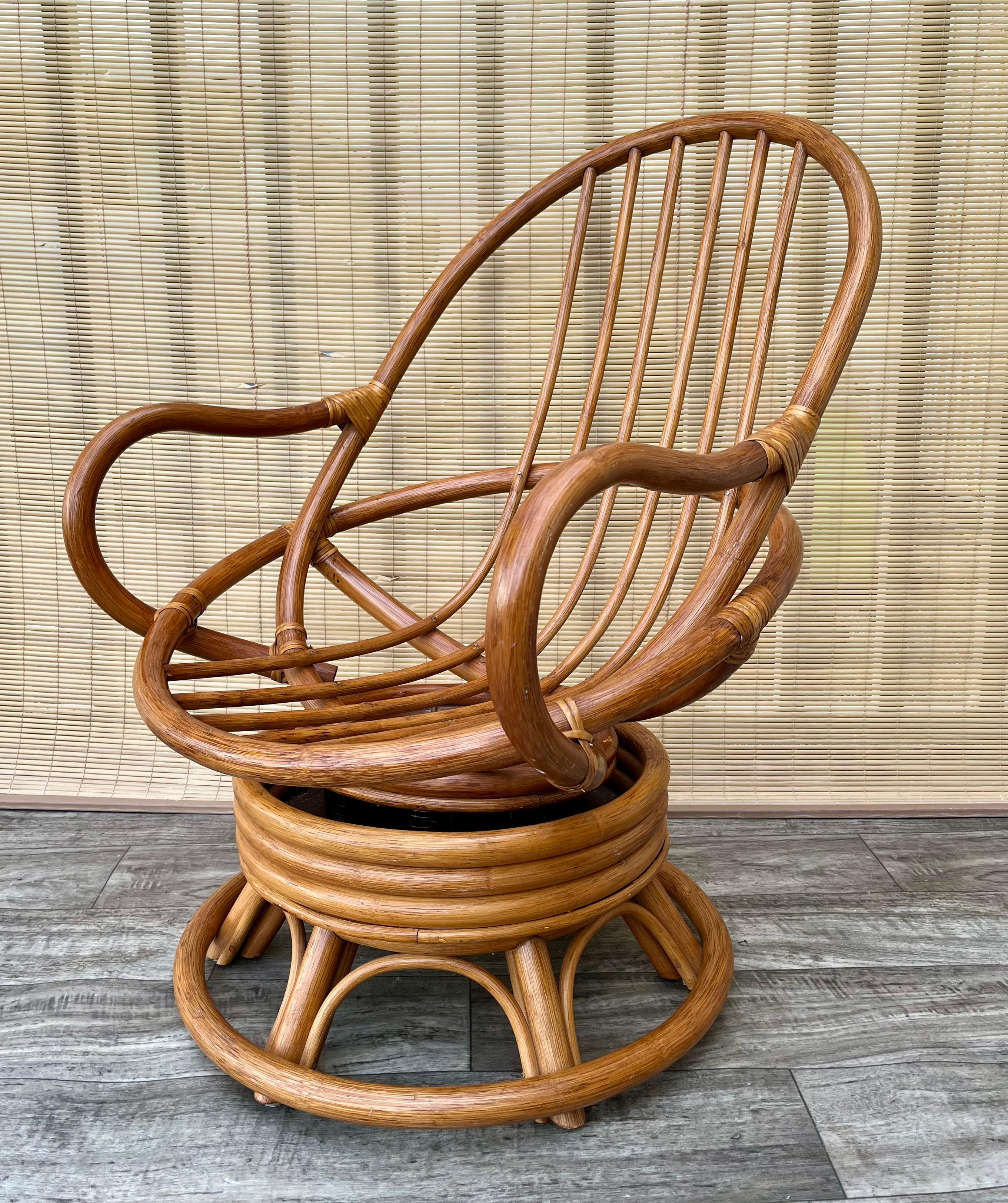 Vintage Bohemian Style Bent Rattan Swivel Lounge Chair in der Paul Frankl's Manier. Circa 1970er Jahre
Das eiförmige Gestell aus natürlichem Rattan mit fassförmiger Rückenlehne und abgerundeten Armlehnen sorgt für ultimativen Komfort.
Der Rahmen ist