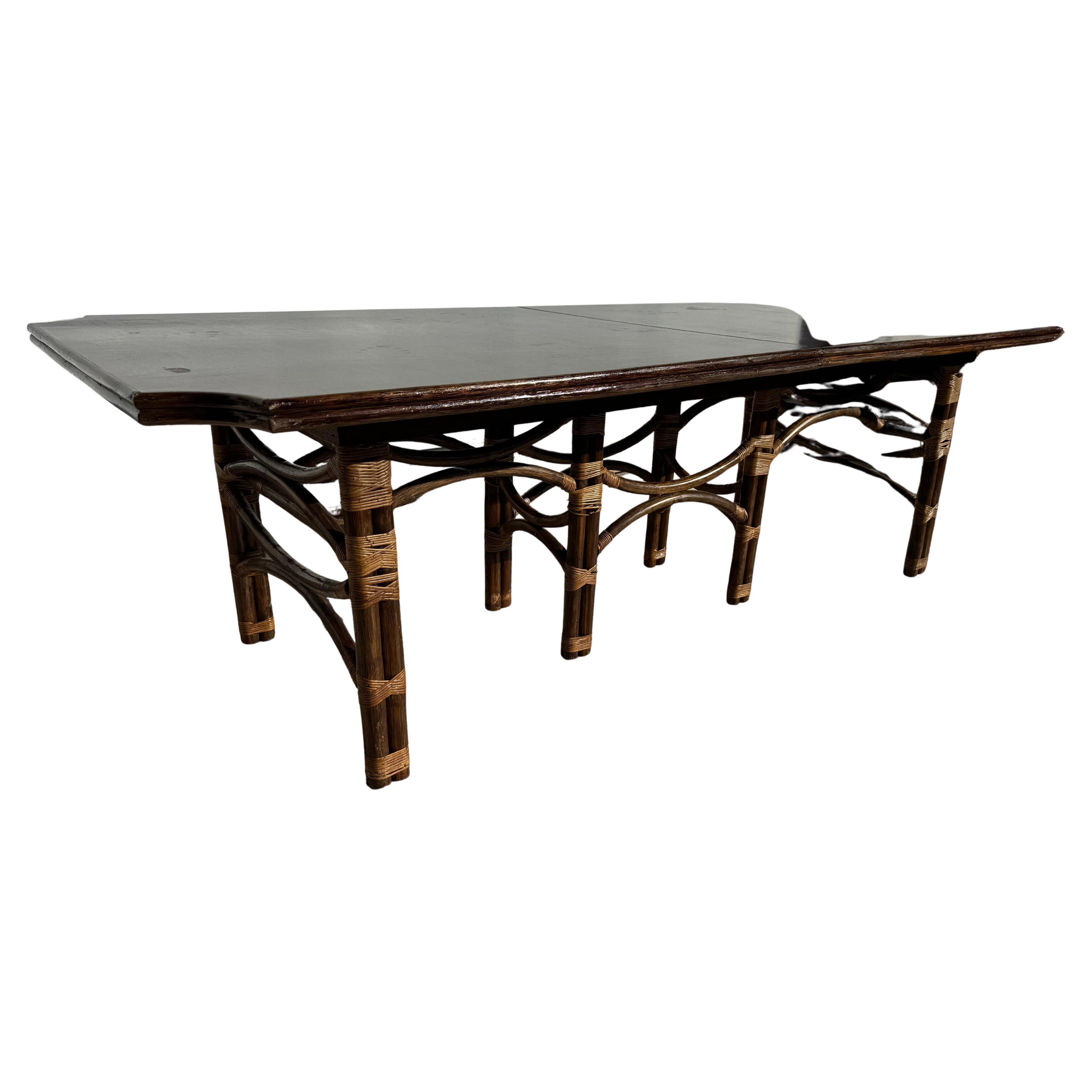 This is a wonderfully made Boho Chic dining table.
The base is constructed of bamboo rods held together with 
bamboo twine. The top interlocks onto the base for a tight sturdy fit.
The table top is made of teak and has a pop-up or butterfly