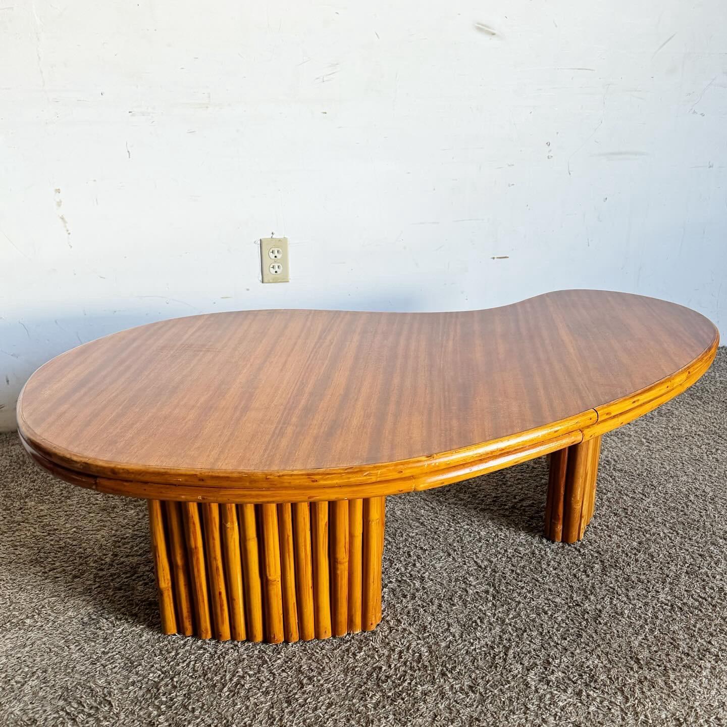 Améliorez votre espace de vie avec le charme unique de cette table basse en bambou en forme de rein Boho Chic. Dotée d'un plateau en bois en forme de rein, élégamment encadré de bambou, cette table allie textures naturelles et design moderne.