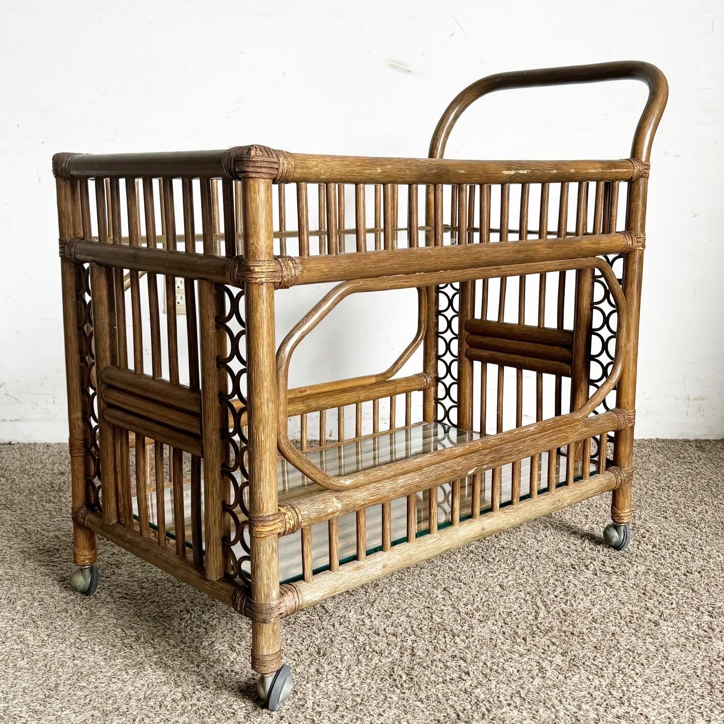 Introduisez une touche d'élégance bohème dans votre accueil avec le chariot de bar à deux niveaux en rotin de bambou et verre Boho Chic. Cette pièce allie la chaleur organique du bambou naturel et du rotin à l'élégance des étagères en verre, offrant