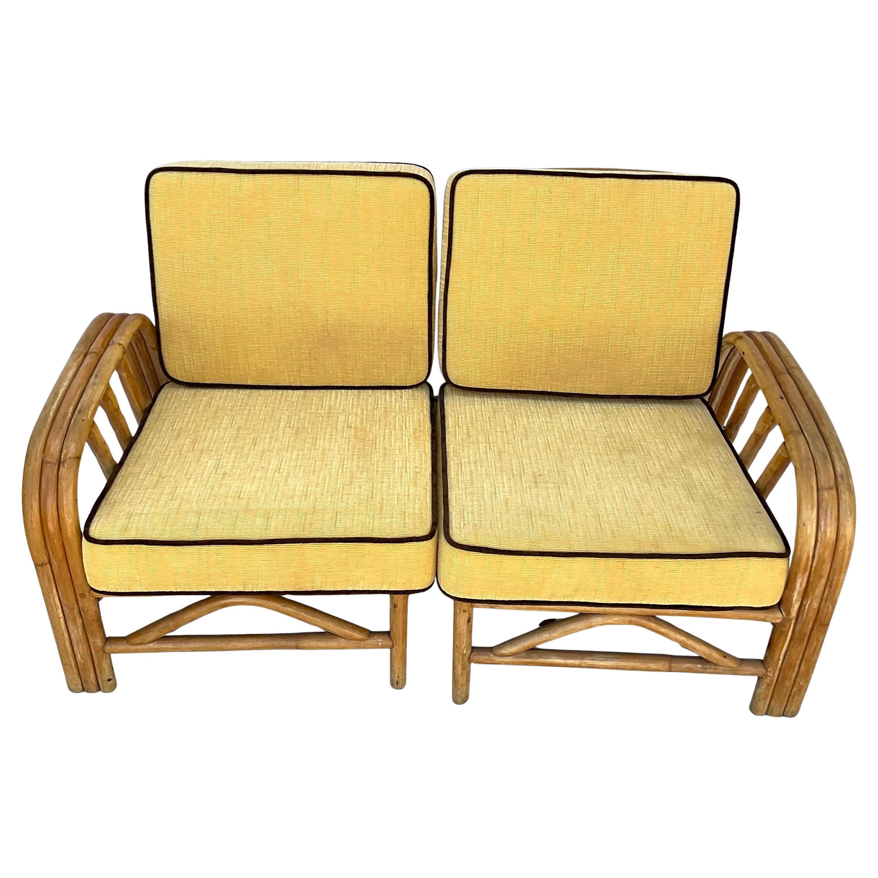 Loveseat de ratán Bohemian Chic del siglo XX con cojines amarillos de felpa y tejido natural. El sofá de dos plazas presenta un armazón de ratán esculpido, con un intrincado tejido y curvas fluidas que acentúan el diseño de inspiración bohemia. El