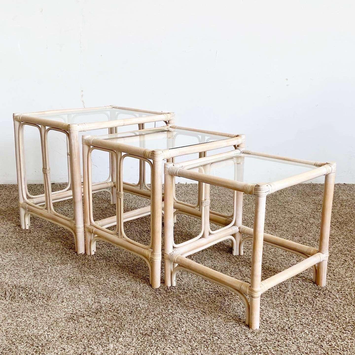 Excellent set of 3 vintage boho chic bamboo rattan nesting side tables. Each feature a white washed finish with inlaid glass tops.

Small table measures 16.75”W, 16”D, 17.75”H
Medium table measures 19.5”W, 17”D, 19.5”H