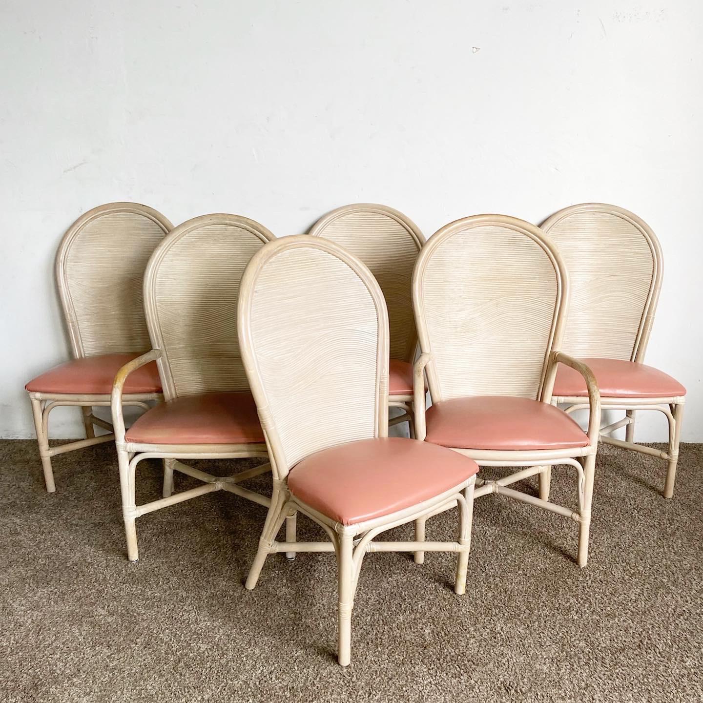 Enhance your dining space with our set of six Boho Chic Bamboo Rattan Wavy Pencil Reed Dining Chairs, featuring peach vinyl and whitewashed reed frames.

Intricately crafted bamboo and reed frame with a wavy design, finished in whitewash.
Soft peach