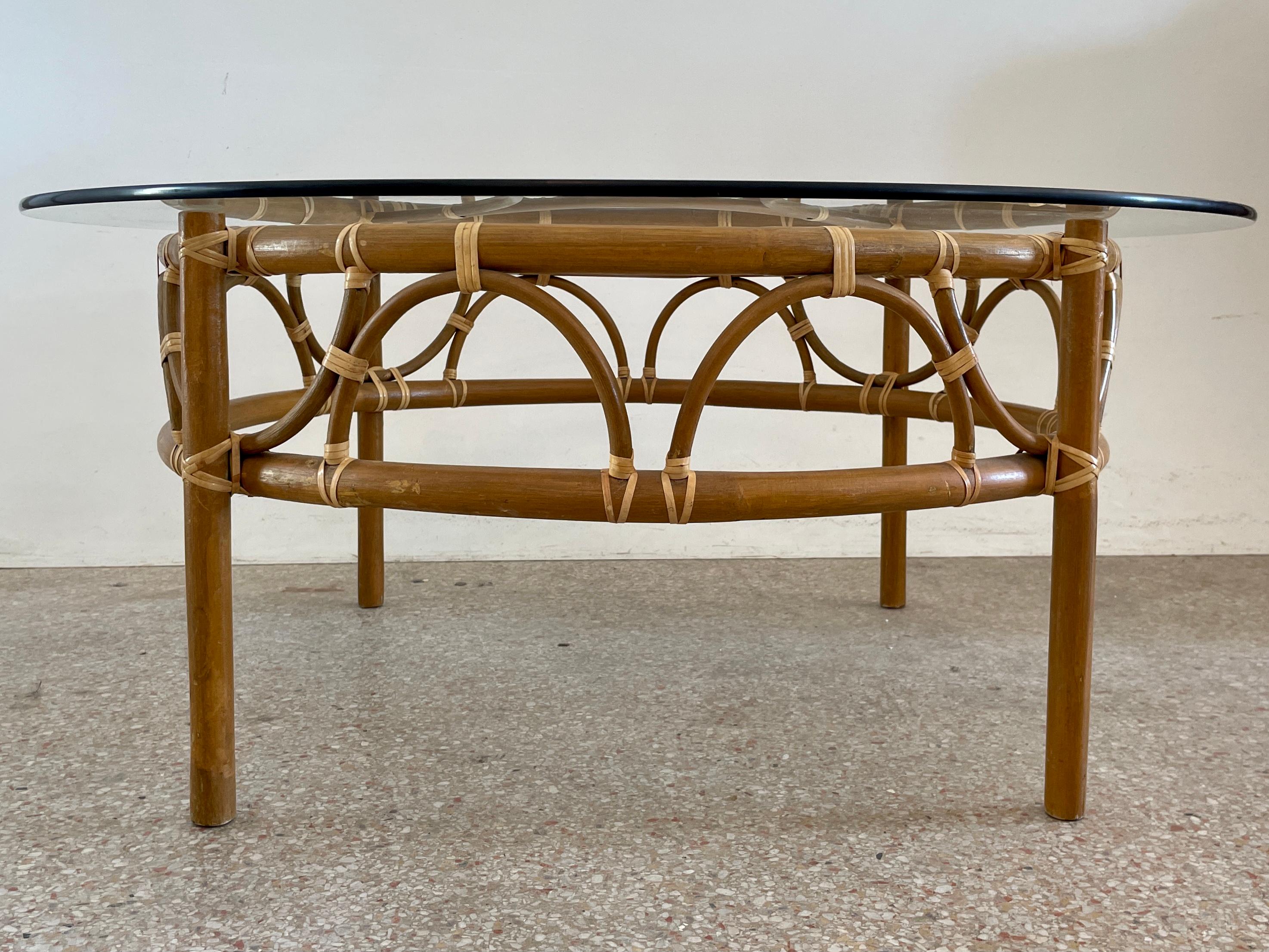 Fabuleuse table basse ronde en rotin de bambou naturel avec un plateau rond en verre. Un complément idéal pour vos intérieurs d'inspiration Boho Chic.