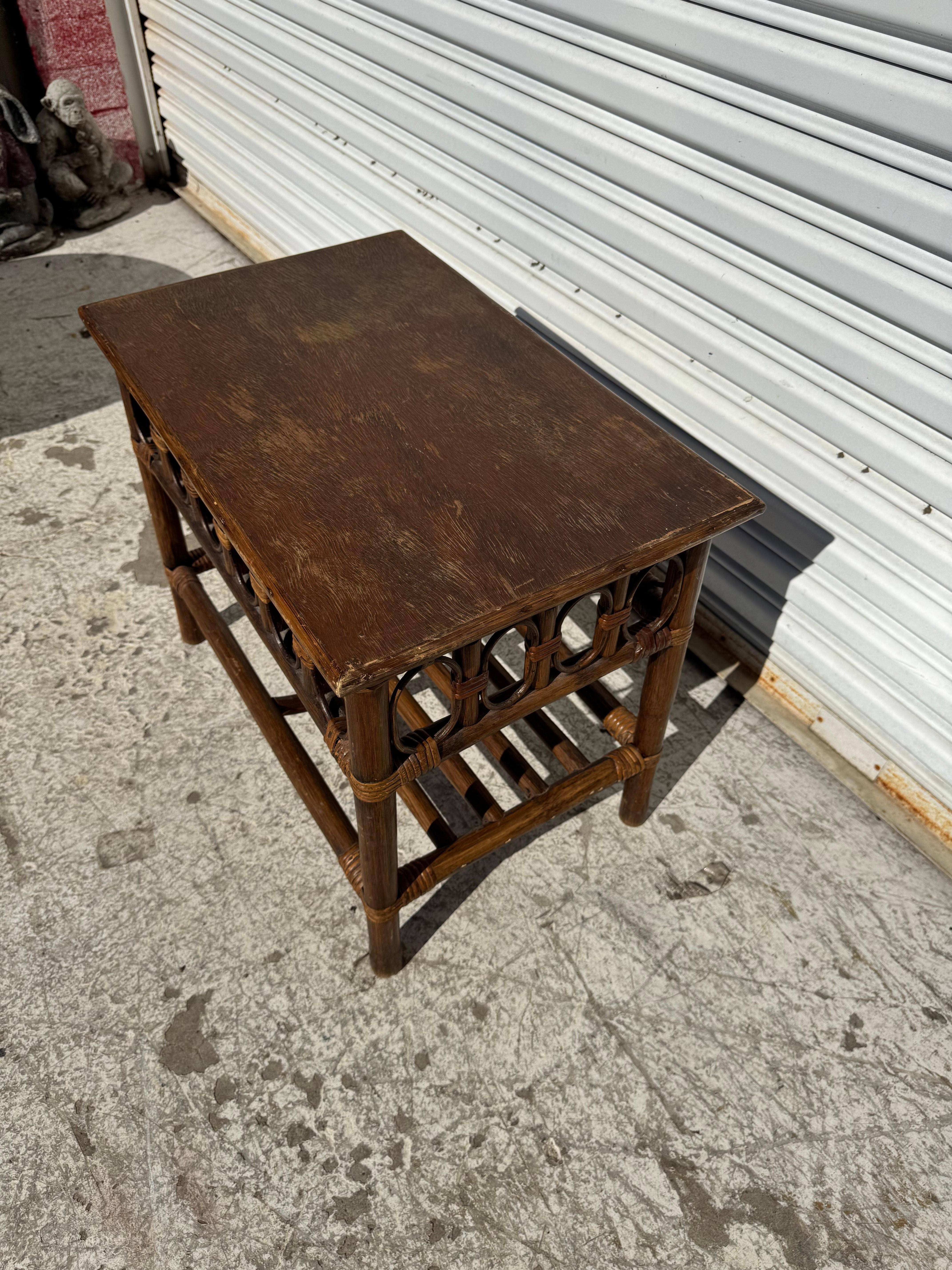 This Boho Chic side table is made of bamboo.
The top is made of  solid wood.
The lower shelf is made of bamboo rods and it has 
an aqua-duct like skirt.  

Refinished upon sale.
