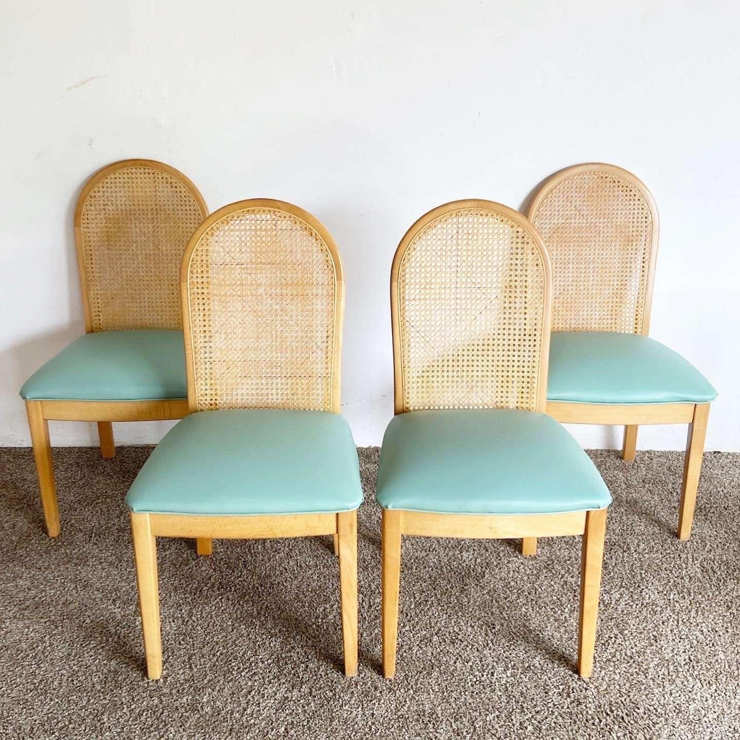 Exceptional set of 4 vintage boho chic dining chairs. Each feature a cane backrest with tufted blue vinyl.

