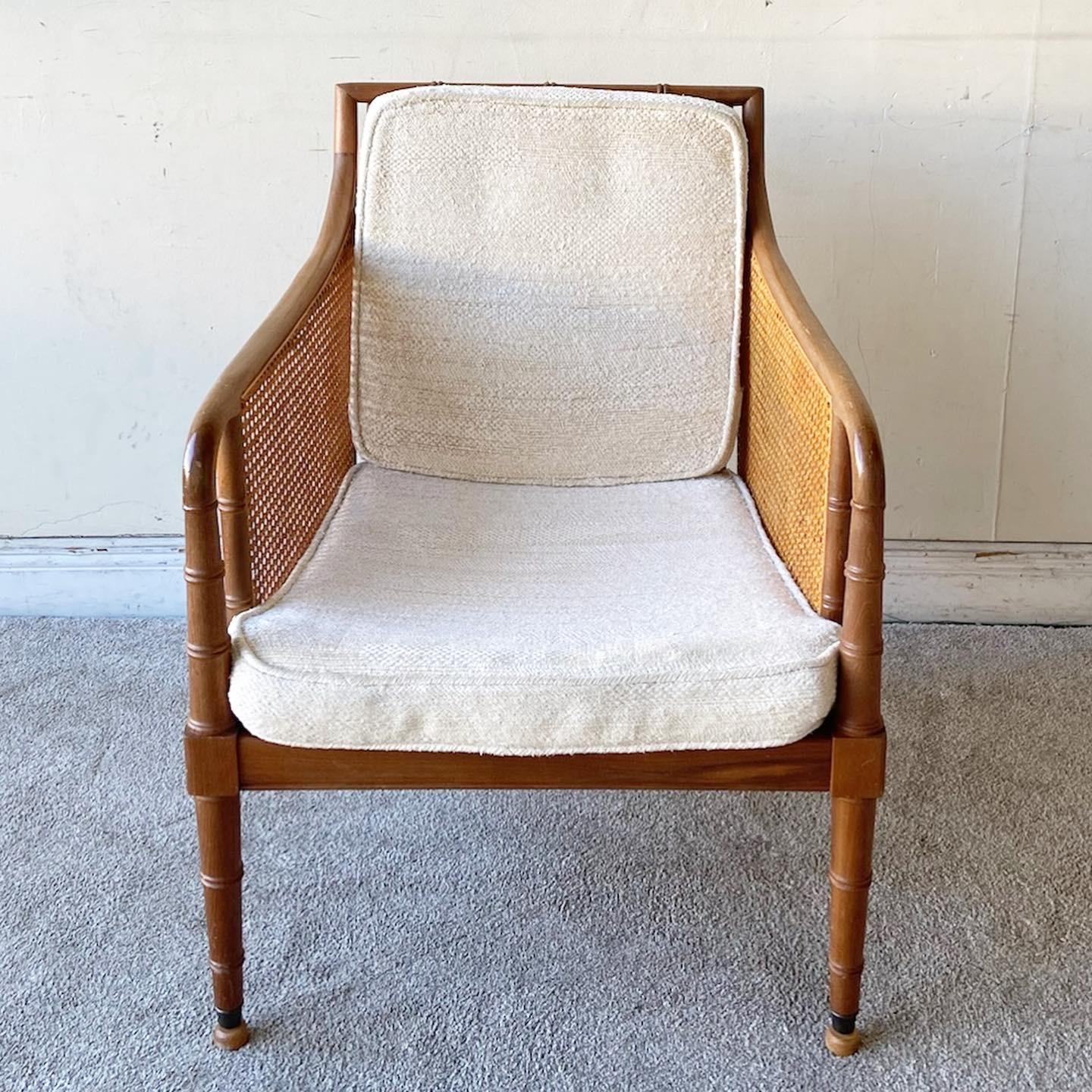 Exceptional vintage faux bamboo arm chair. Features can sides and back rests with two white cushions.
 