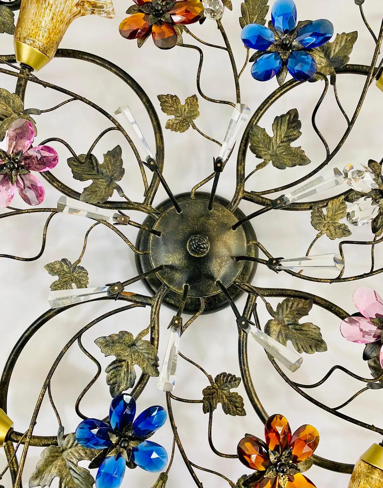 An exquisite wide flowers and leaves Bohemian style ceiling lighting or chandelier. The chandelier features multi-color flowers in faux crystal and leaves in a adardk bronzed tone. The chandelier has 4 lights with tulip shaped shades. This whimsical