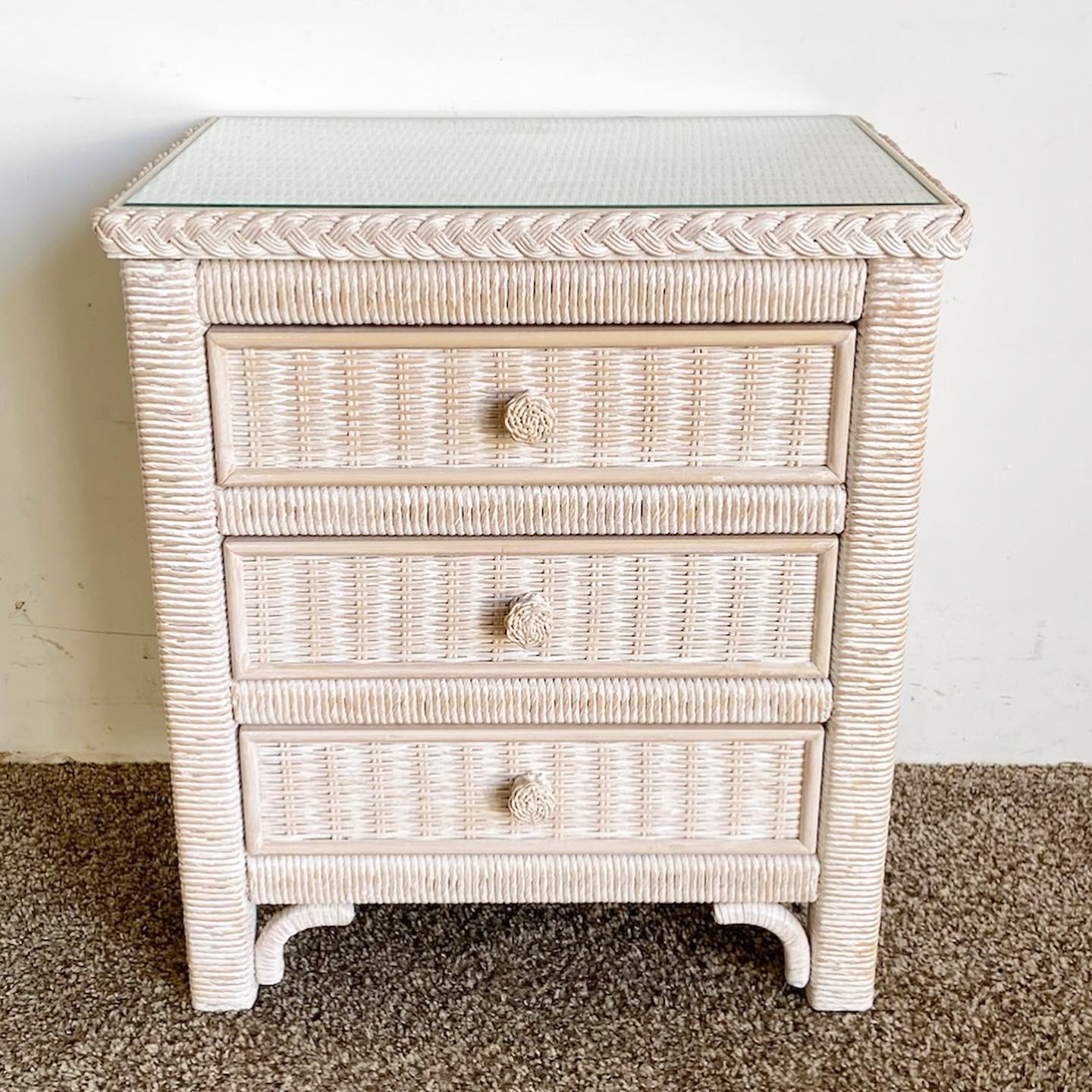 Add a touch of boho chic to your space with the wonderful vintage Lexington wicker rattan commode/nightstand by Henry Link. This piece features an inlaid glass top, pickle pink finish, and provides both style and functionality.

Wonderful vintage