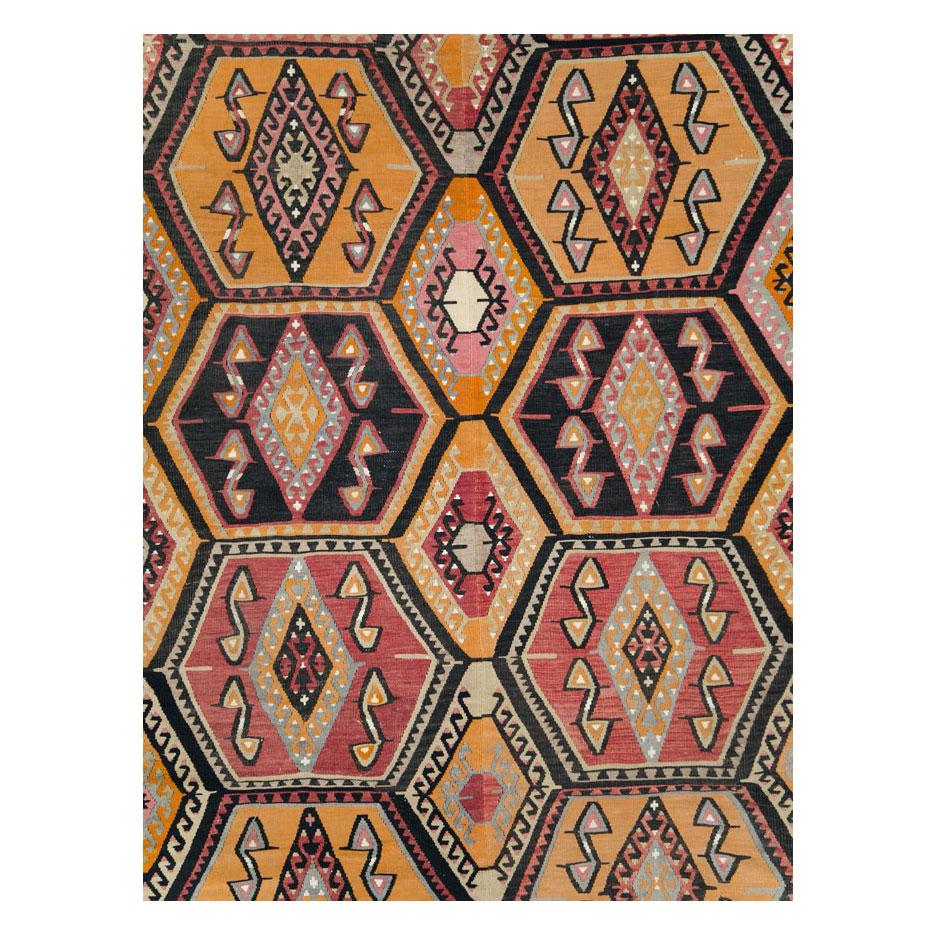 A vintage Turkish flatweave Kilim large room size carpet handmade during the mid-20th century with a tribal pattern that works well with bohemian chic interior design.

Measures: 10' 10