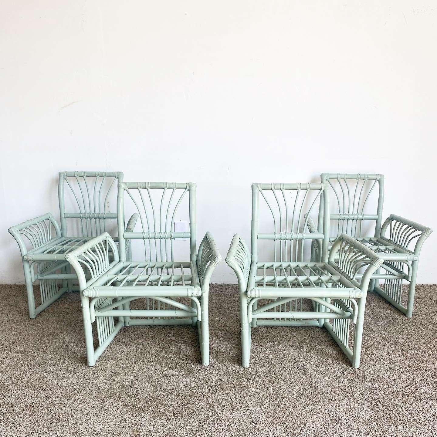 Incredible vintage bohemian bamboo rattan dining set. Set contains 4 exceptional flared arm chairs with a matching dining table base which holds up a large square beveled glass top. The set is finished with a mint green paint.

Table measures 48”W,