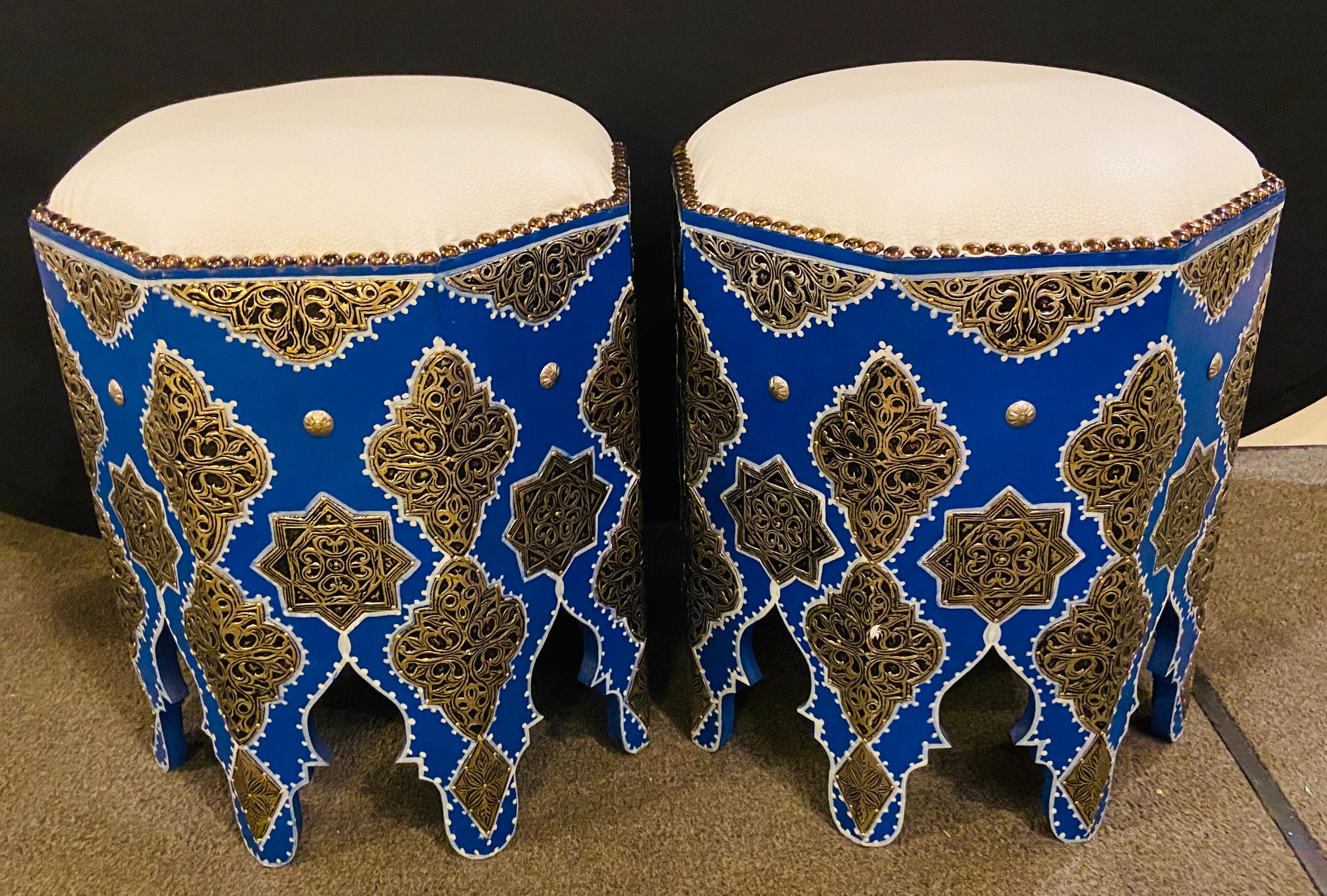 Un tabouret ou ottoman marocain bleu Boho Chic avec dessus en cuir blanc. Les tabourets sont peints à la main en bleu Majorelle (d'après le jardin Majorelle à Marrakech) avec un design blanc et présentent un travail filigrané en laiton argenté ainsi