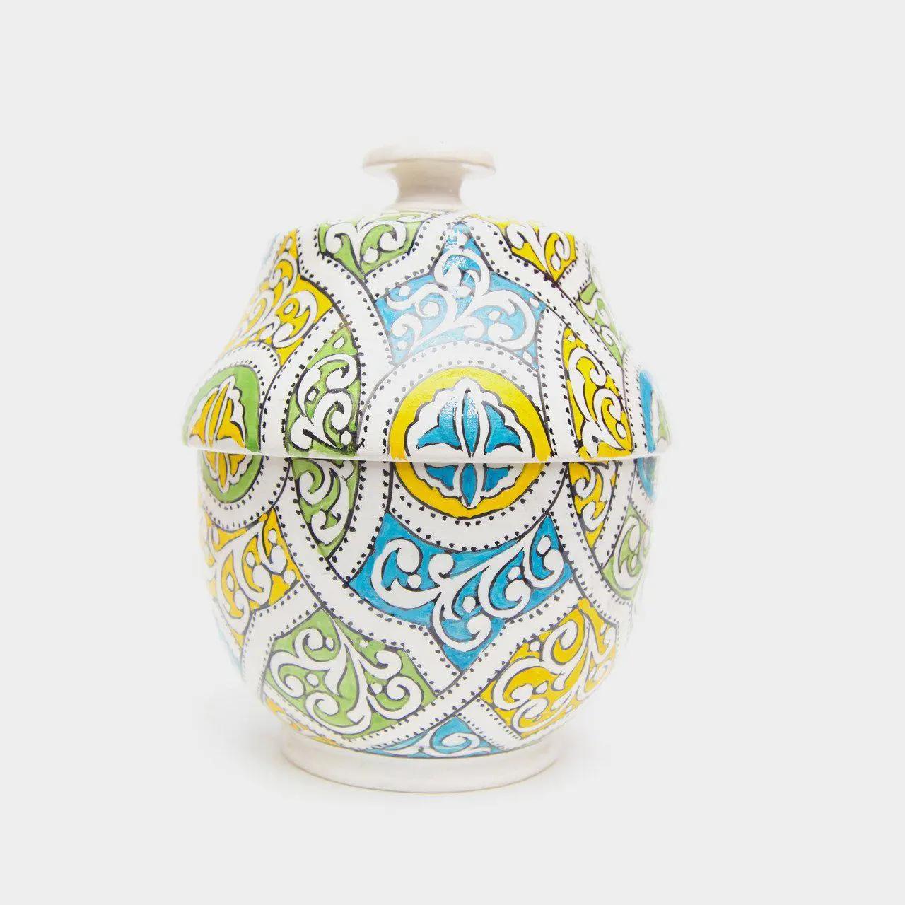 This entrancing Moroccan urn or jar is a dazzling example of tradition-based craftsmanship. Made from high-quality white ceramic (similar to porcelain) and boasting an ornate, hand-painted arabesque motif in turquoise, yellow and green, these jars