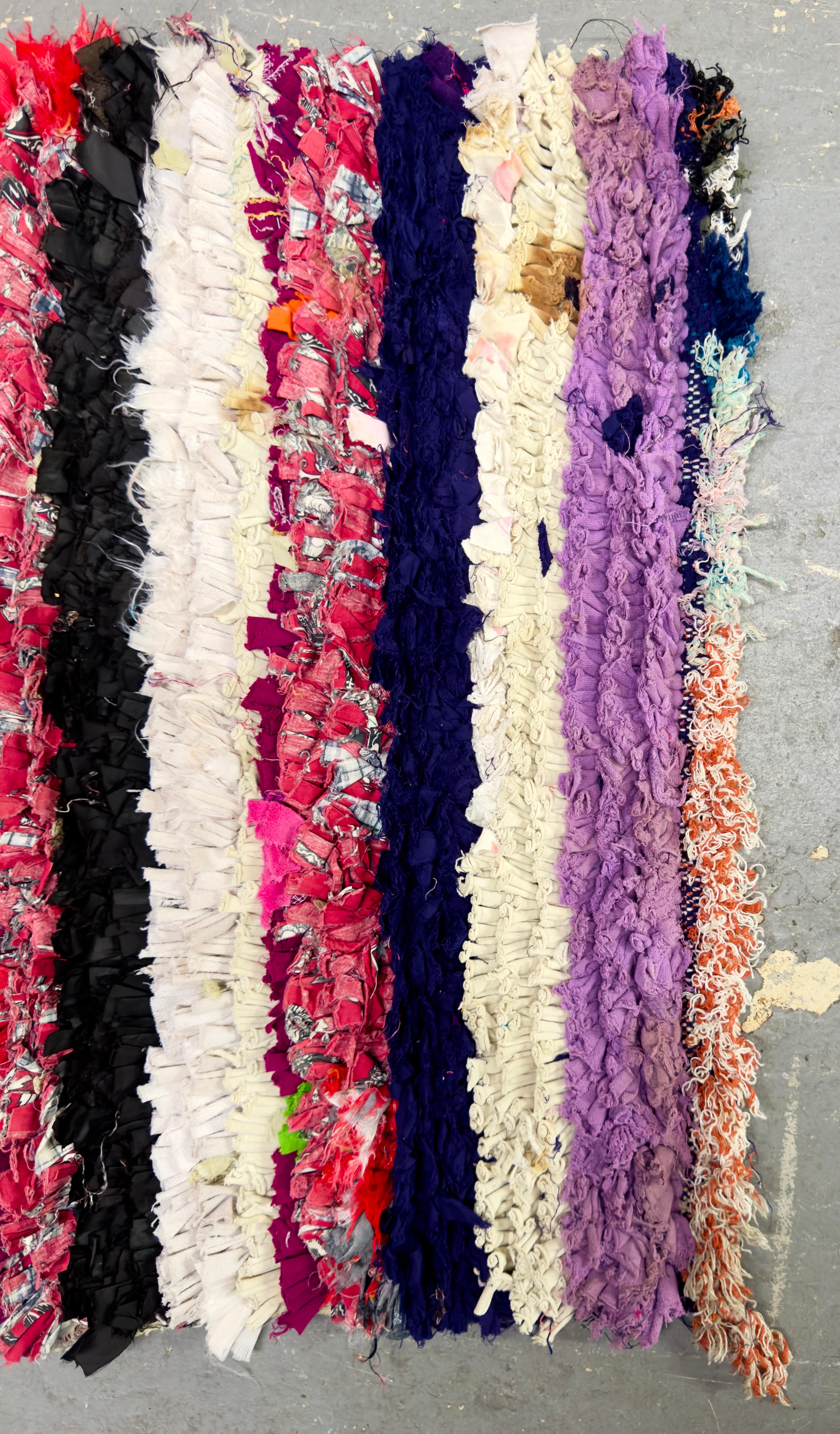 Un petit tapis ou une moquette Boho Chic à rayures multicolores marocaines.  Avec ses couleurs vives et joyeuses, le tapis est une pièce unique faite à la main à partir de chutes de tissus recyclés transformés en une belle œuvre d'art. Le petit