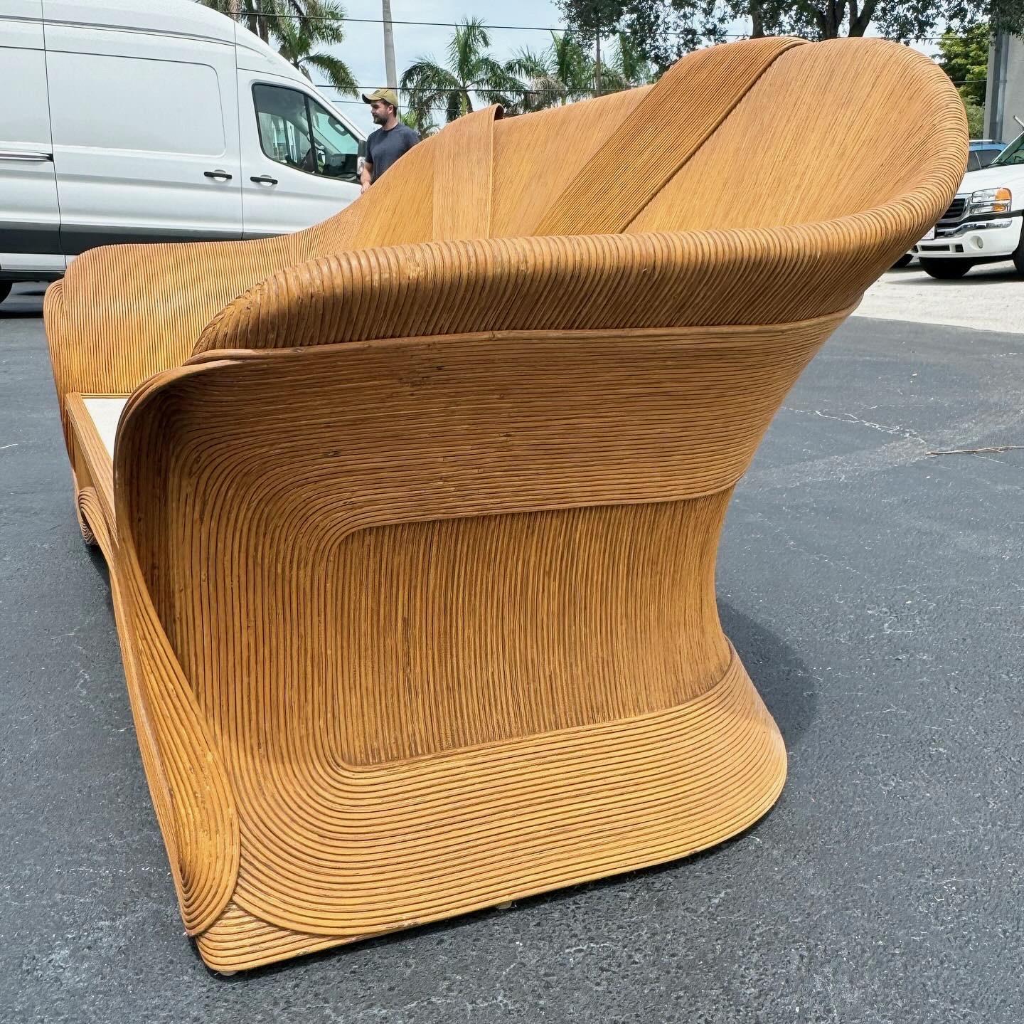 Introduci un tocco di eleganza bohémien nel tuo spazio abitativo con questo divano Boho Chic con nastro a matita. Questo capolavoro vintage presenta un design unico a nastro e una costruzione meticolosa di canne a matita, creando un'estetica