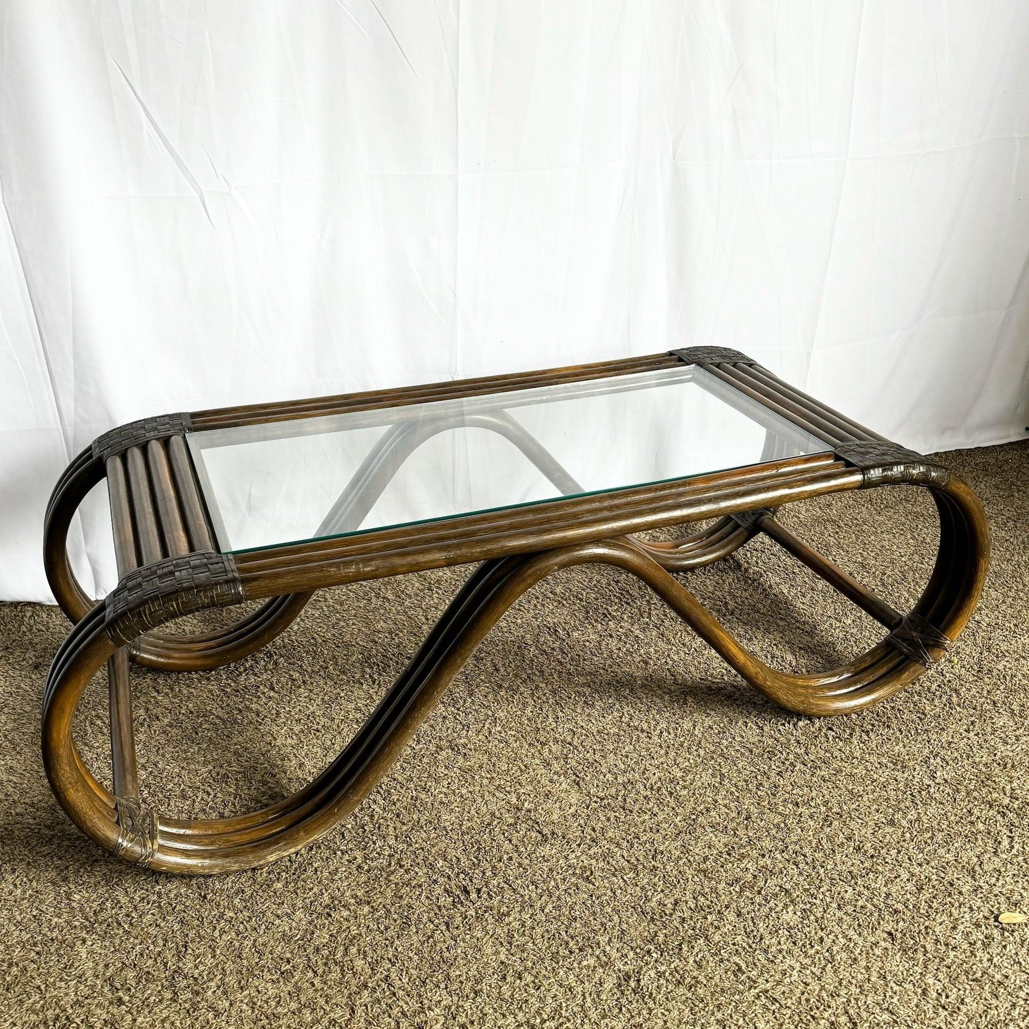 Table basse Boho Chic en rotin avec un tissage en cuir, un design sculptural et un plateau en verre, parfaite pour ajouter de la chaleur à une décoration côtière ou tropicale.
 
 Petites éraflures et usure sur les bords, comme le montrent les