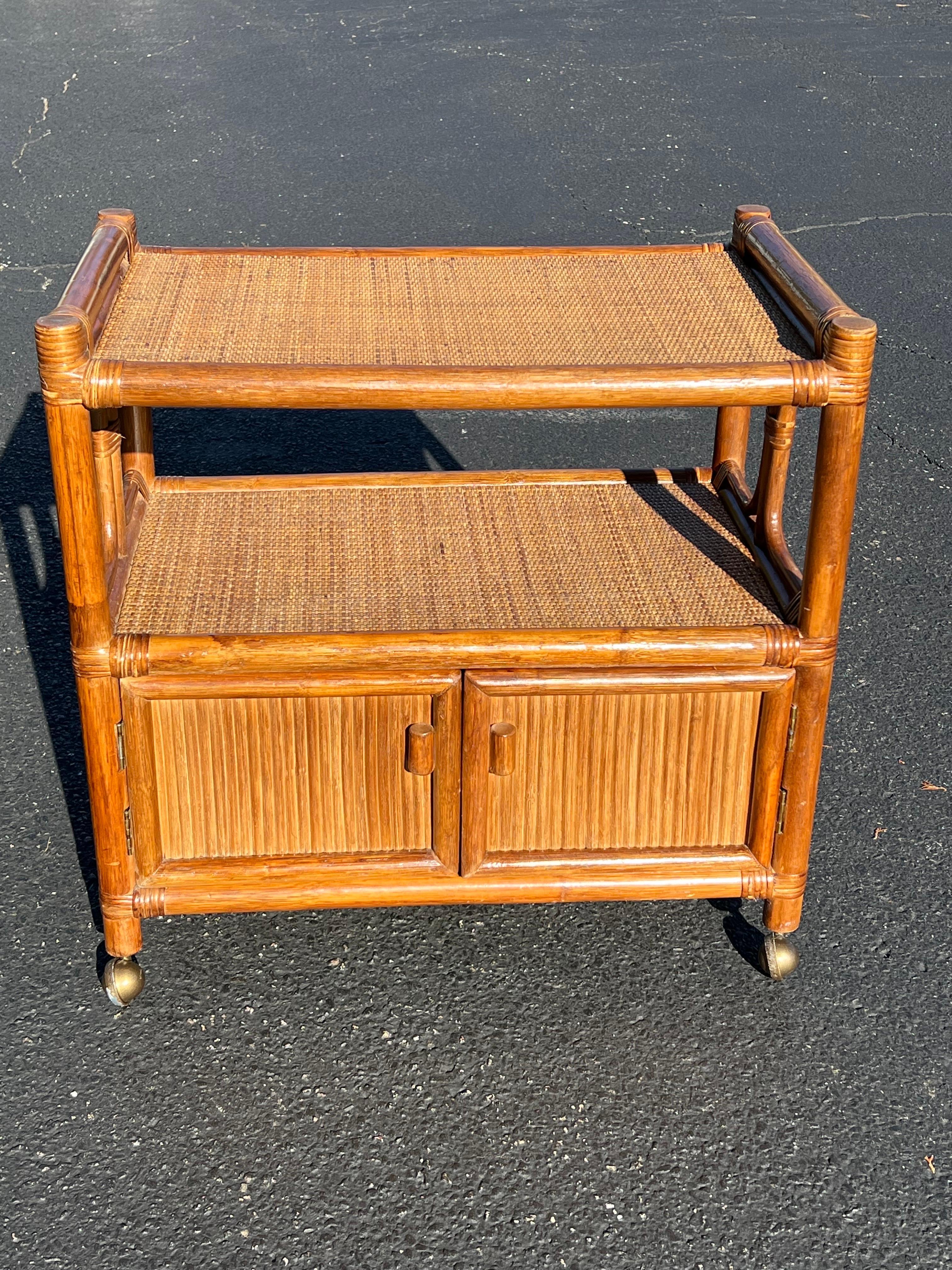 Boho Chic Rattan and wicker Bar Cart. Wicker top and bottom shelf with rattan structure. Cabinet doors open to ample space for bottles. Easy to wheel around. Perfect for that coastal home. The interior of the cabinet height is 11” 
The Interior