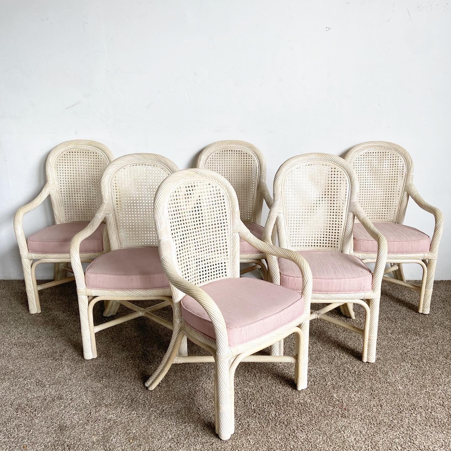 Nos chaises à accoudoirs de salle à manger Boho Chic Twisted Pencil Reed Cane Back se présentent sous la forme d'un lot de six, offrant un charme éclectique grâce à leurs coussins roses et à leur design unique.

Il se caractérise par une