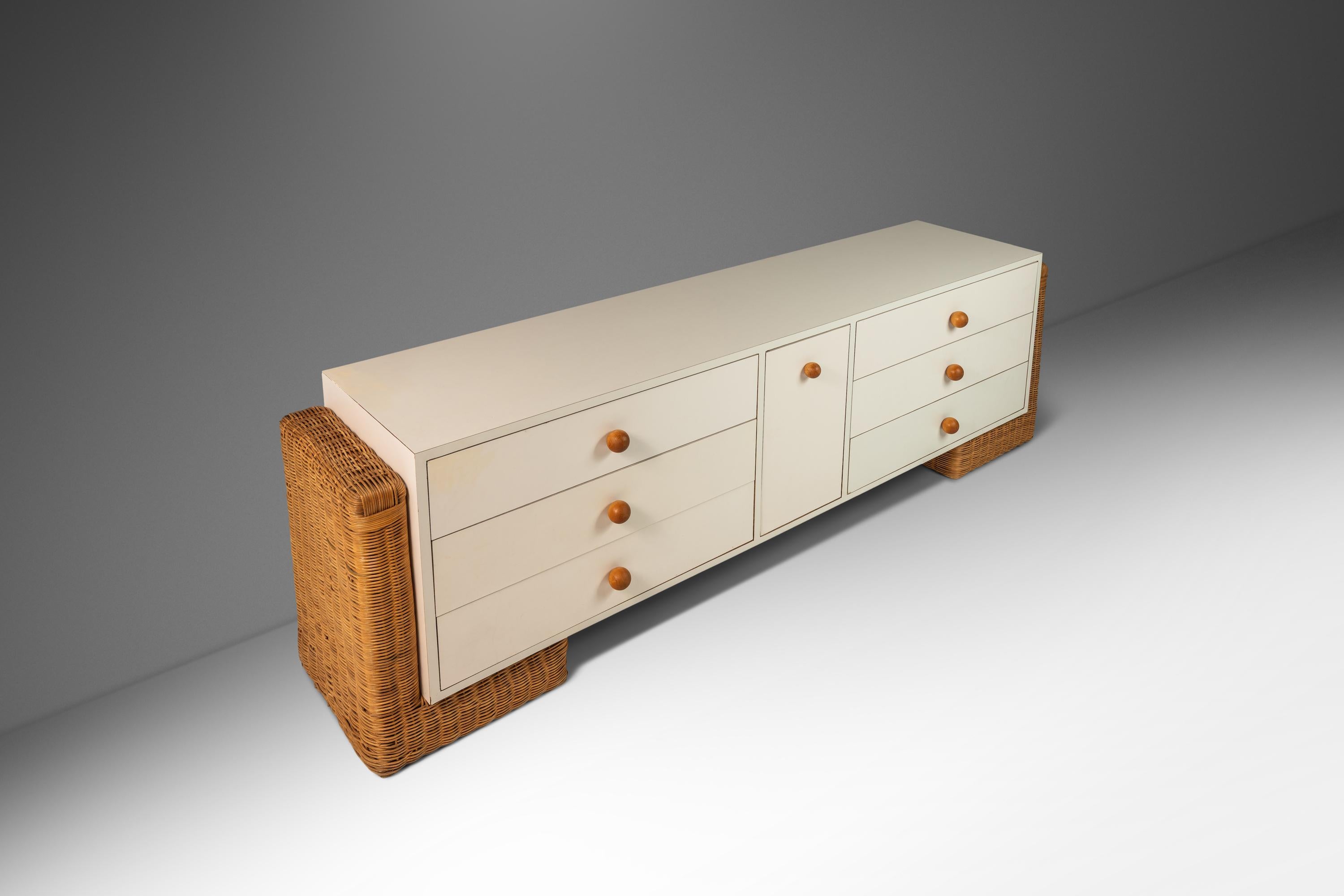 Exemple ludique mais raffiné du design des années 1980, cette longue commode unique, pièce de rangement ou buffet, équilibre les sensibilités Boho Chic avec des lignes modernes et épurées. La pièce présente un corps minimaliste revêtu de stratifié