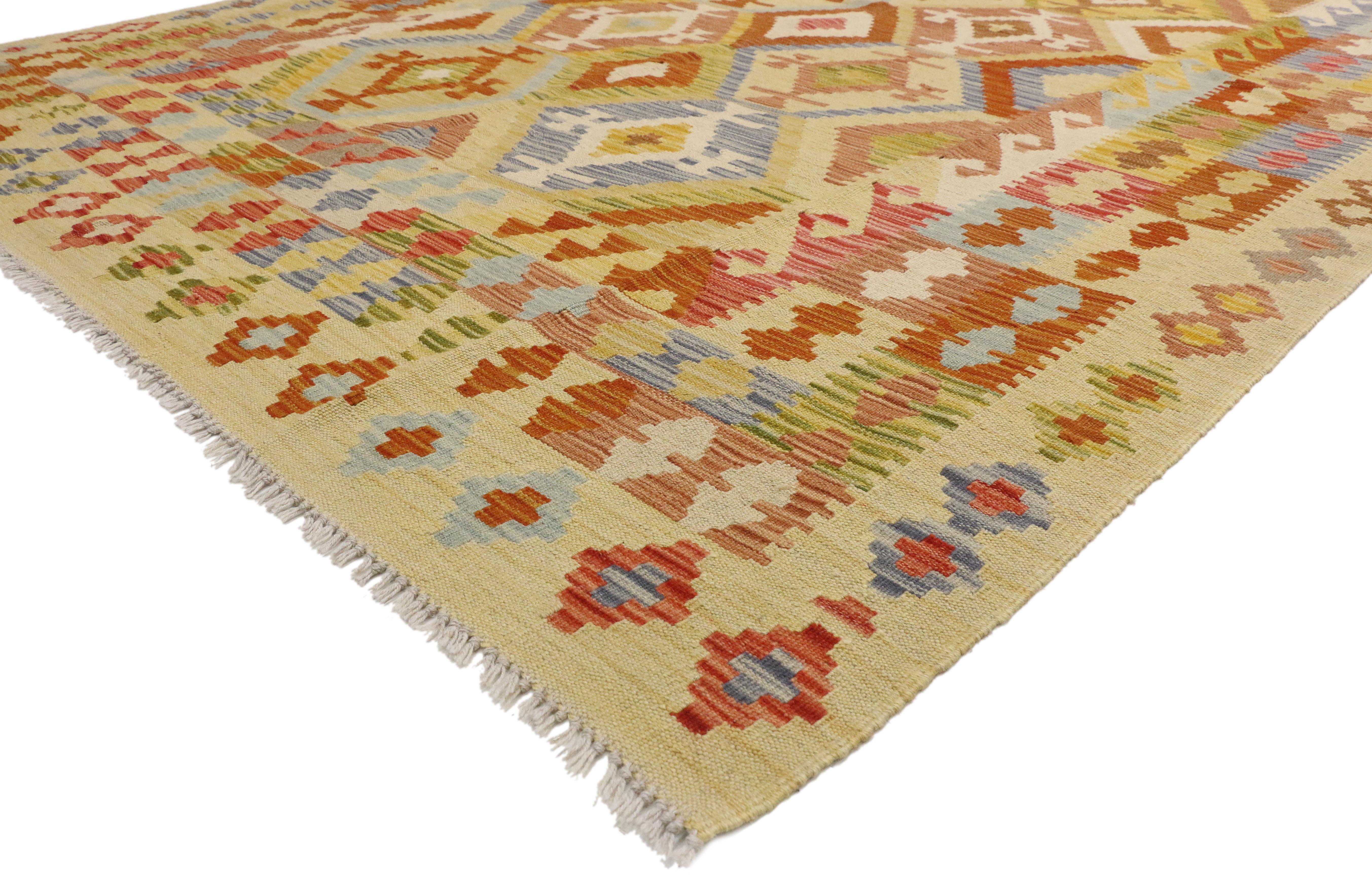 80132 vintage Afghani Kilim rug, 06’10 x 09’09. Full of tiny details and nomadic charm, this handwoven wool vintage Afghan kilim rug is a captivating vision of woven beauty. The eye-catching tribal design and vibrant earth-tone colors woven into