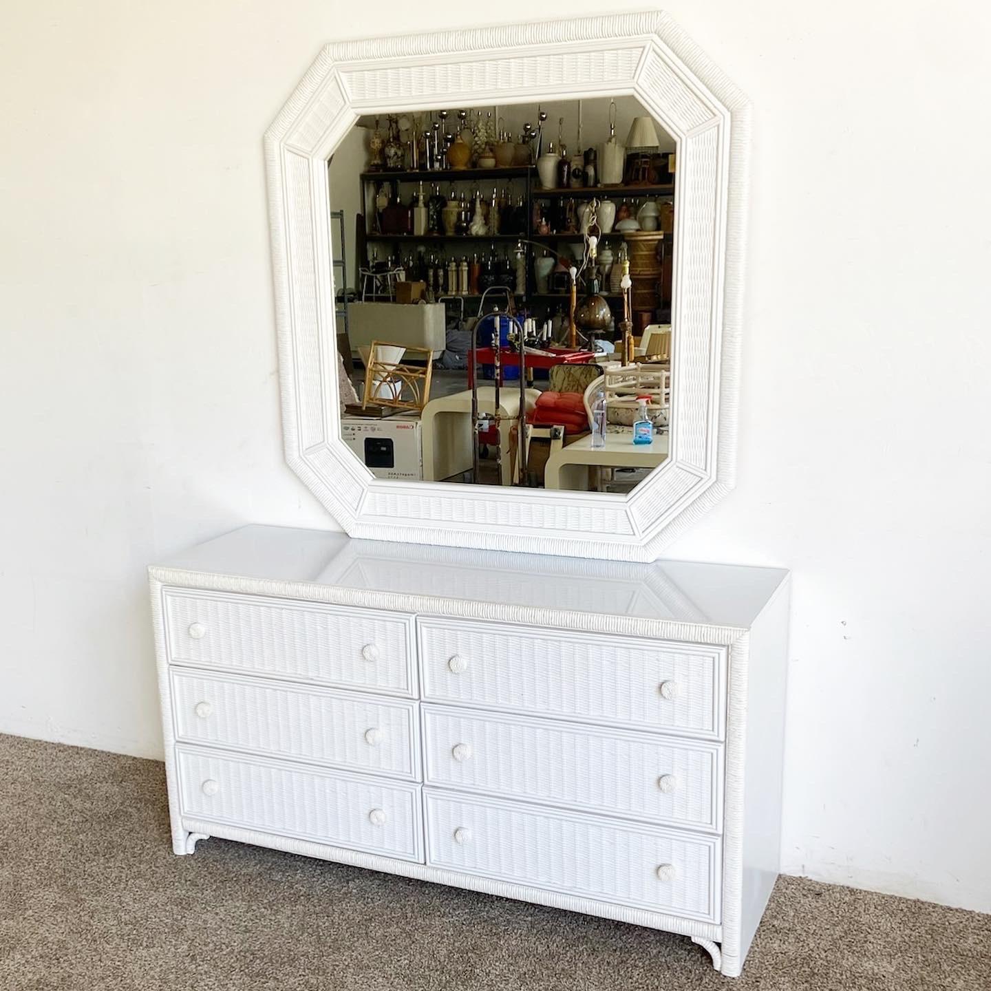 Wonderful vintage boho chic dresser with matching mirror. Features a white finish with a faux rattan framing and faux wicker drawer faces.

Mirror measures 46.5”W, 1”D, 46.5”H.