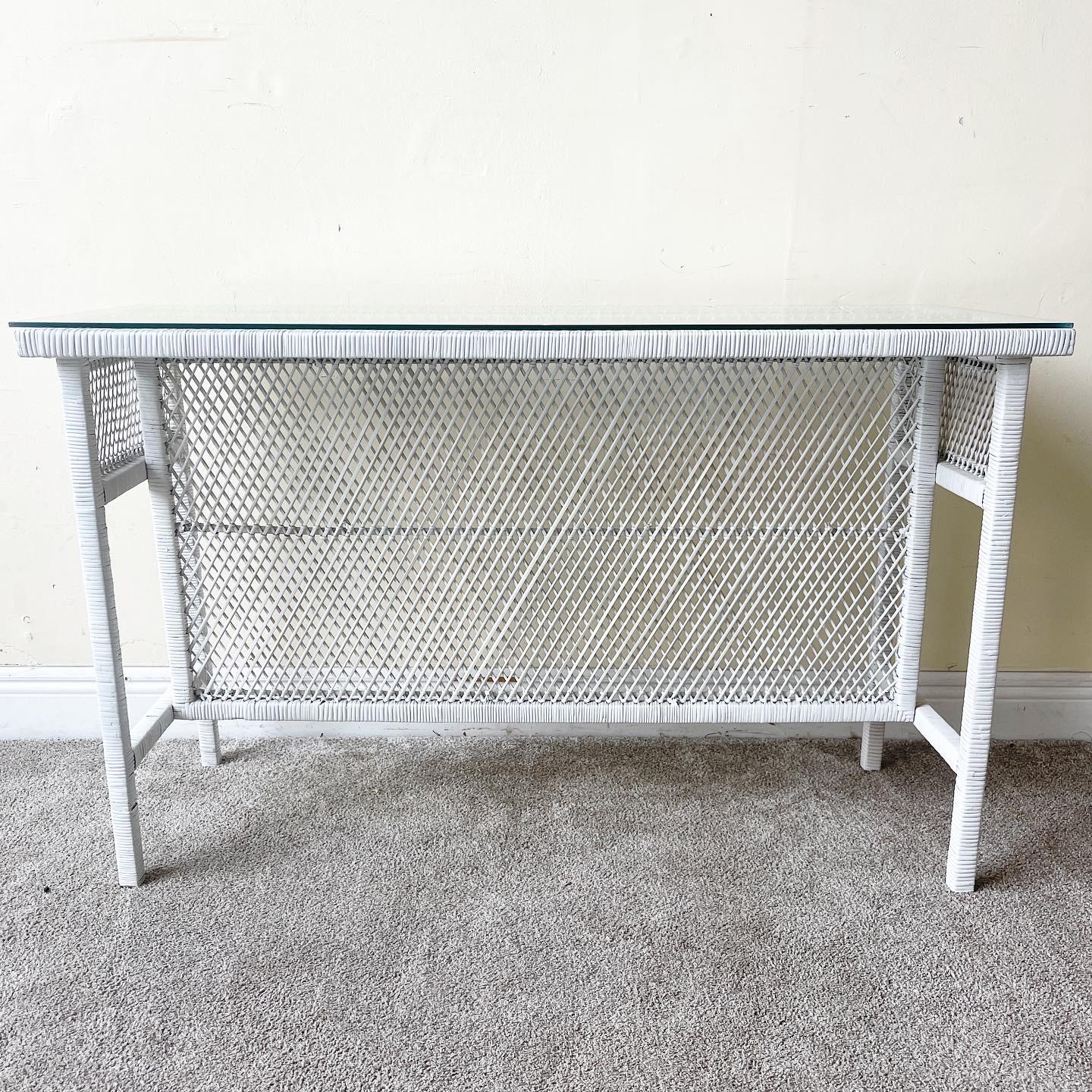 Incredible rattan console table. Features a white painted finish with a rectangular glass top.
 