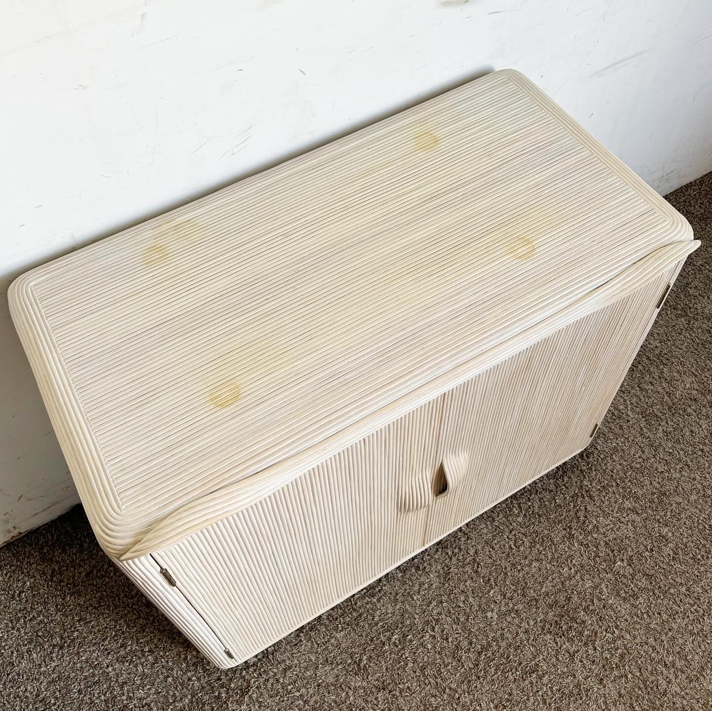 Infusez votre espace avec une élégance bohémienne avec cette armoire à crayons/bordure Boho Chic White Washed Ribbon Pencil Reed Cabinet/Sideboard. Fabriquée à partir d'un tissage complexe de rubans et de roseaux, cette pièce offre une texture
