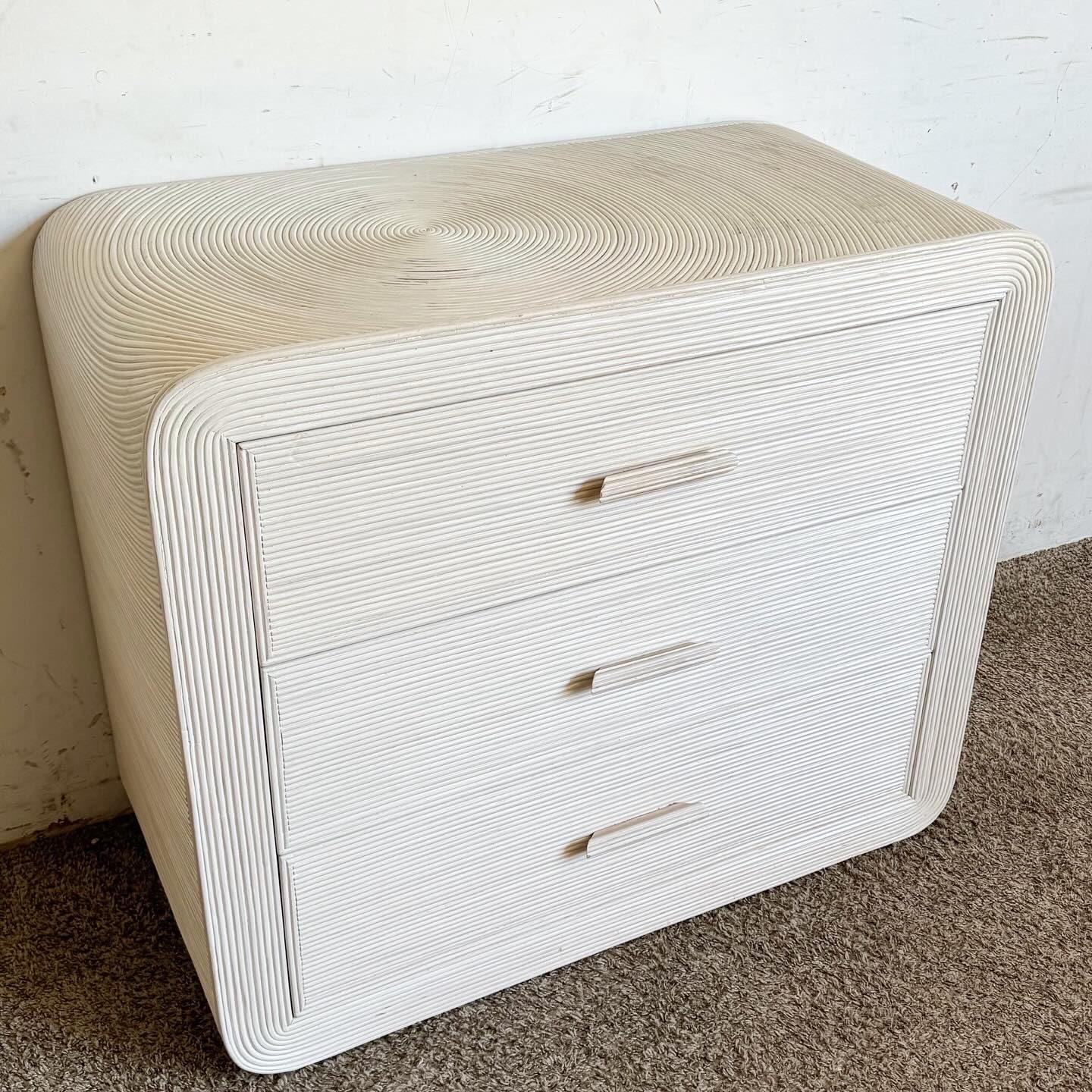 Aggiungi un tocco di fascino artigianale alla tua camera da letto con questa cassettiera Boho Chic White Washed Swirl Pencil Reed Waterfall. Caratterizzata da un accattivante design a vortice di canne e da una finitura bianca lavata, questa