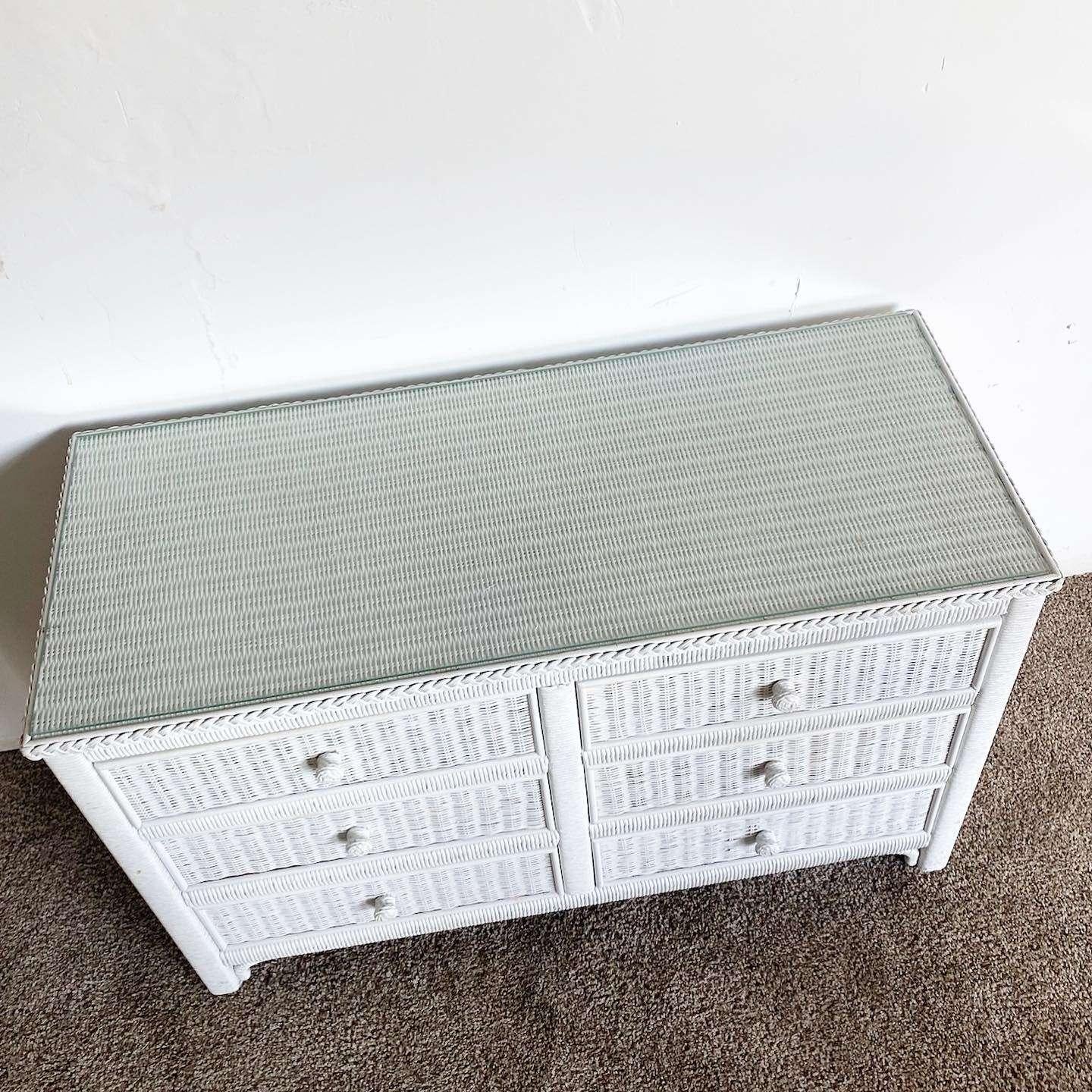 Amazing vintage bohemian wicker and rattan dresser. Features a white painted finish with a glass top and 6 spacious drawers.
