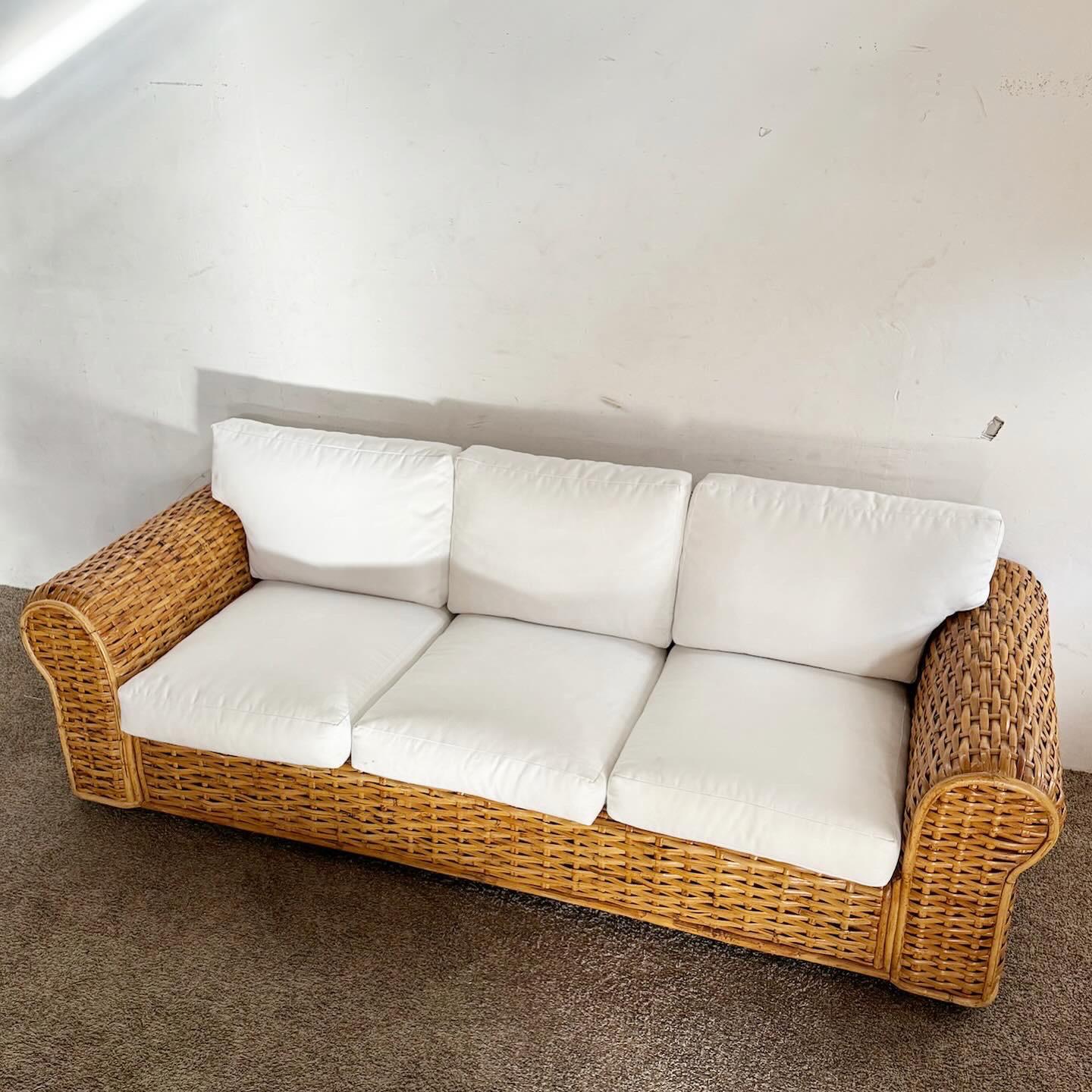 The Boho Chic Wicker Sofa by Polo Ralph Lauren, with its elegant white cushions, offers a blend of comfort and style. Its natural wicker construction and sophisticated design make it ideal for sunrooms, living areas, or patios, embodying laid-back