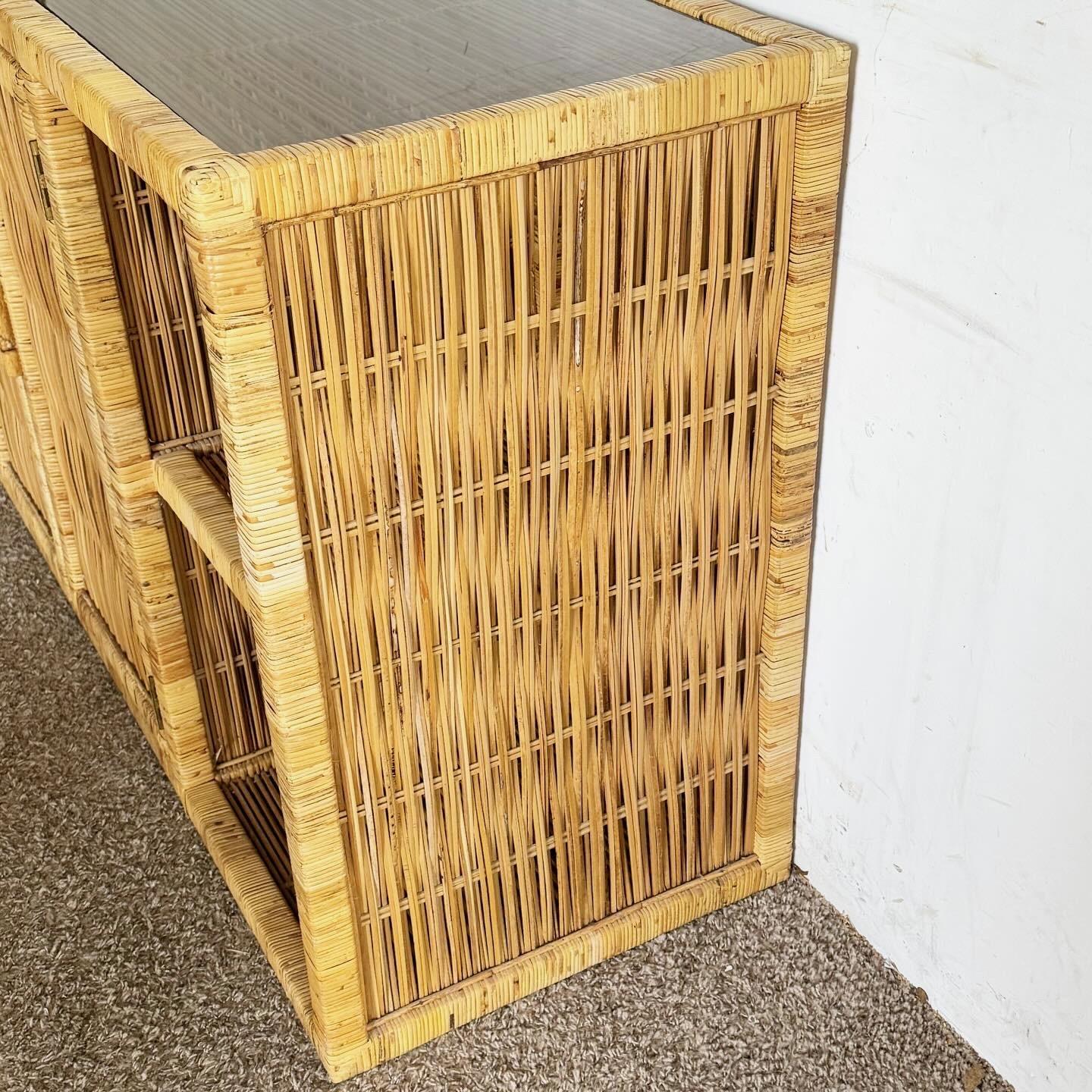 Elevate your home decor with the Boho Chic Woven Rattan Smoked Glass Top Credenza. This stylish piece combines the warmth and texture of woven rattan with the sleek, modern appeal of a smoked glass top. Perfect for adding a touch of bohemian