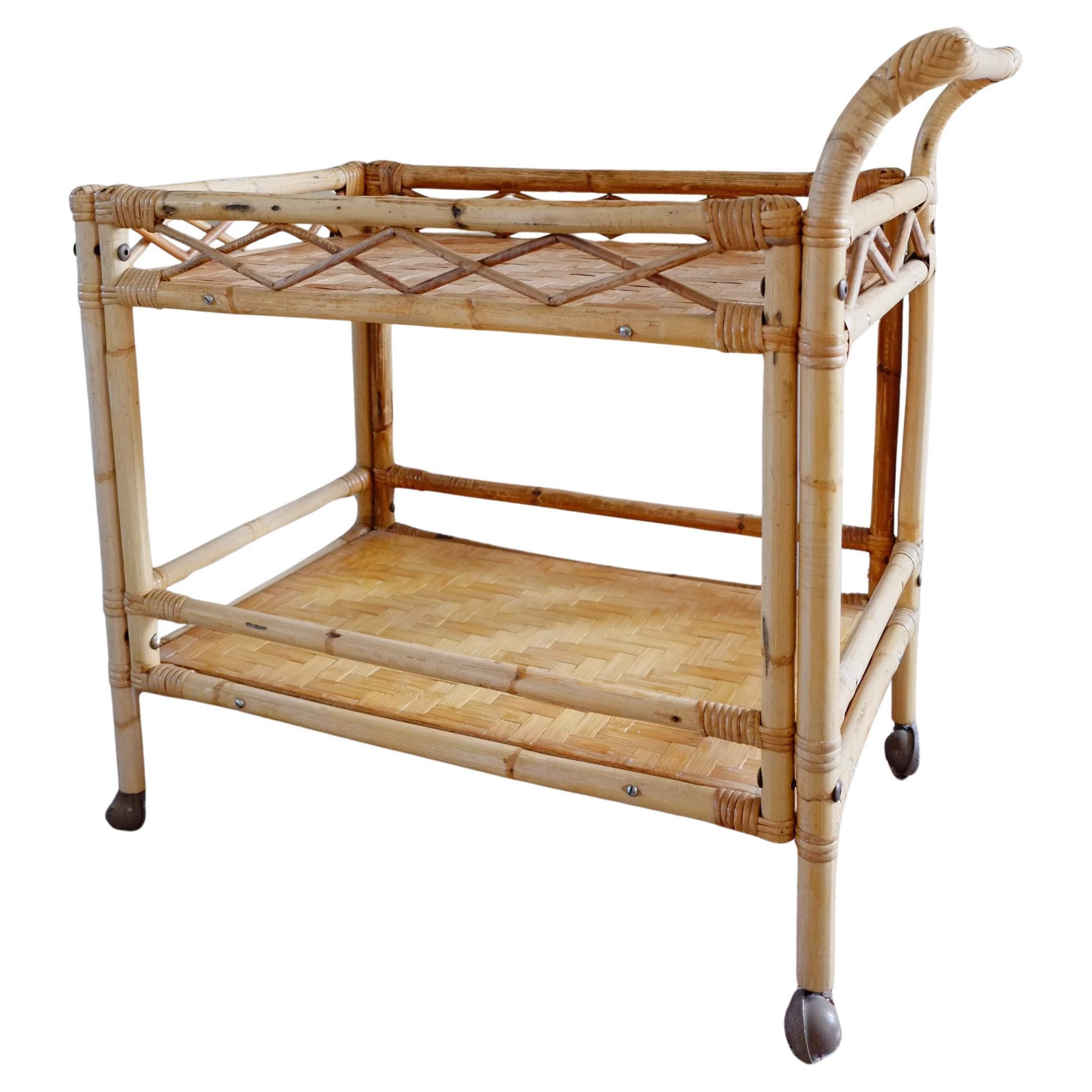 A gorgeous large mid-century cocktail trolley. The drinks cart is made in an attractive bamboo frame with woven rattan trays. The cart has a lovely large size with two rectangular trays.
The drinks trolley has a beautiful form and proportions; and