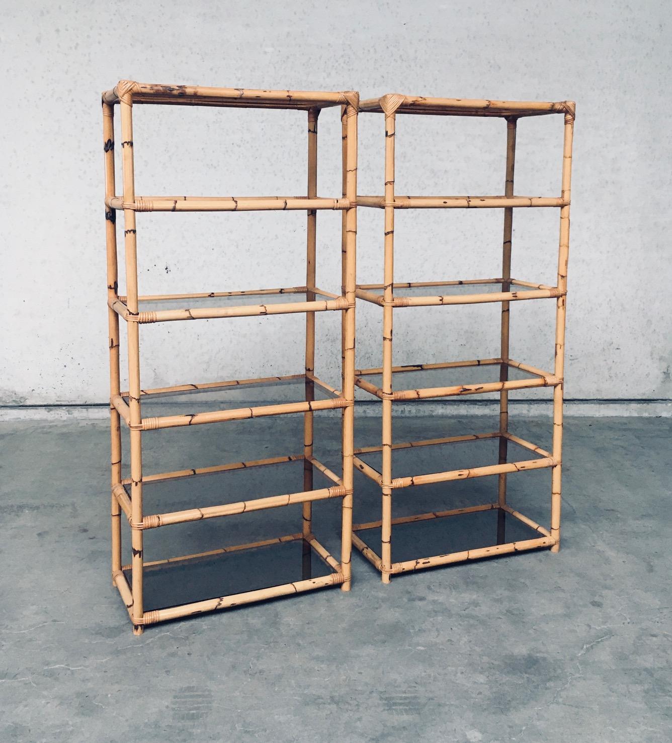 Set di 2 scaffali in bambù dal design vintage in stile boho. Made in Italy, anni '60/'70. Struttura interamente in bambù con ripiani in vetro marrone fumé. Può essere utilizzata come libreria o espositore. Entrambi sono in ottime condizioni, tutti