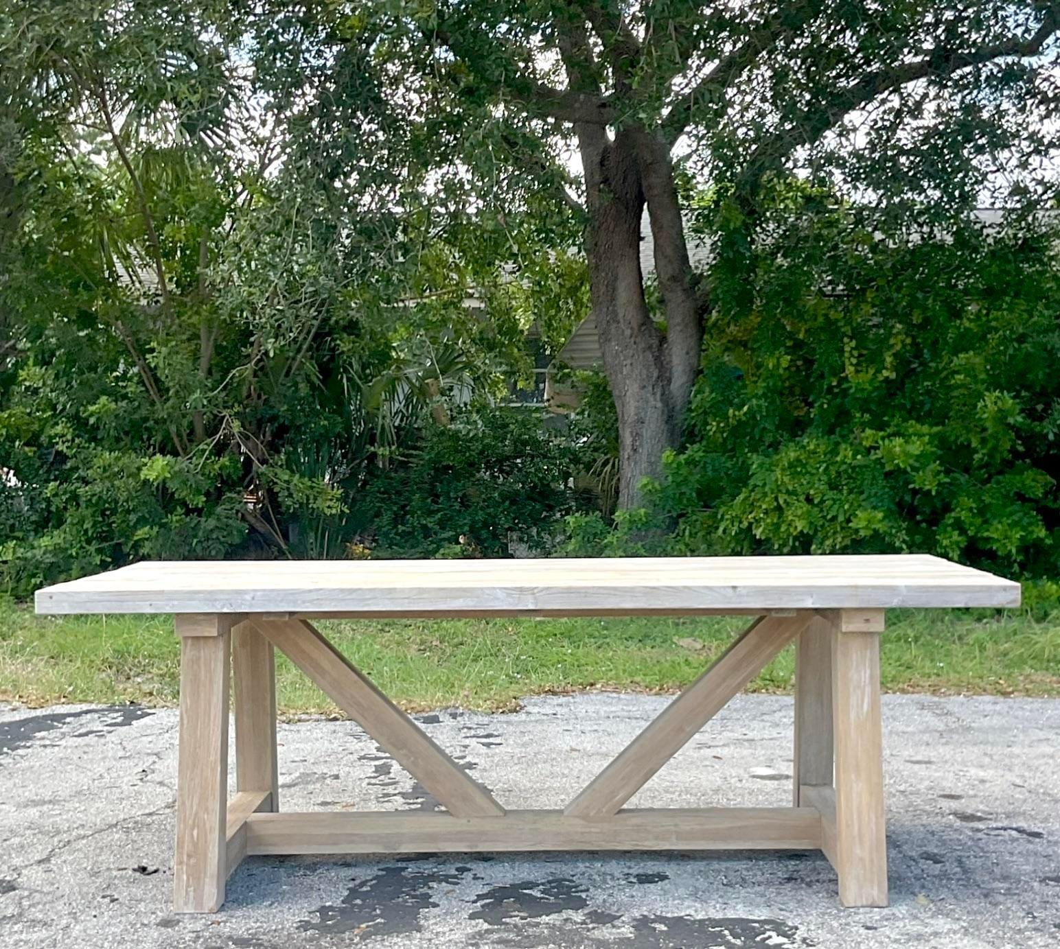 A fabulous vintage Boho farm table. A chic washed reclaimed wood in a classic trestle design. Thick wood top. Acquired from a Palm Beach estate.
